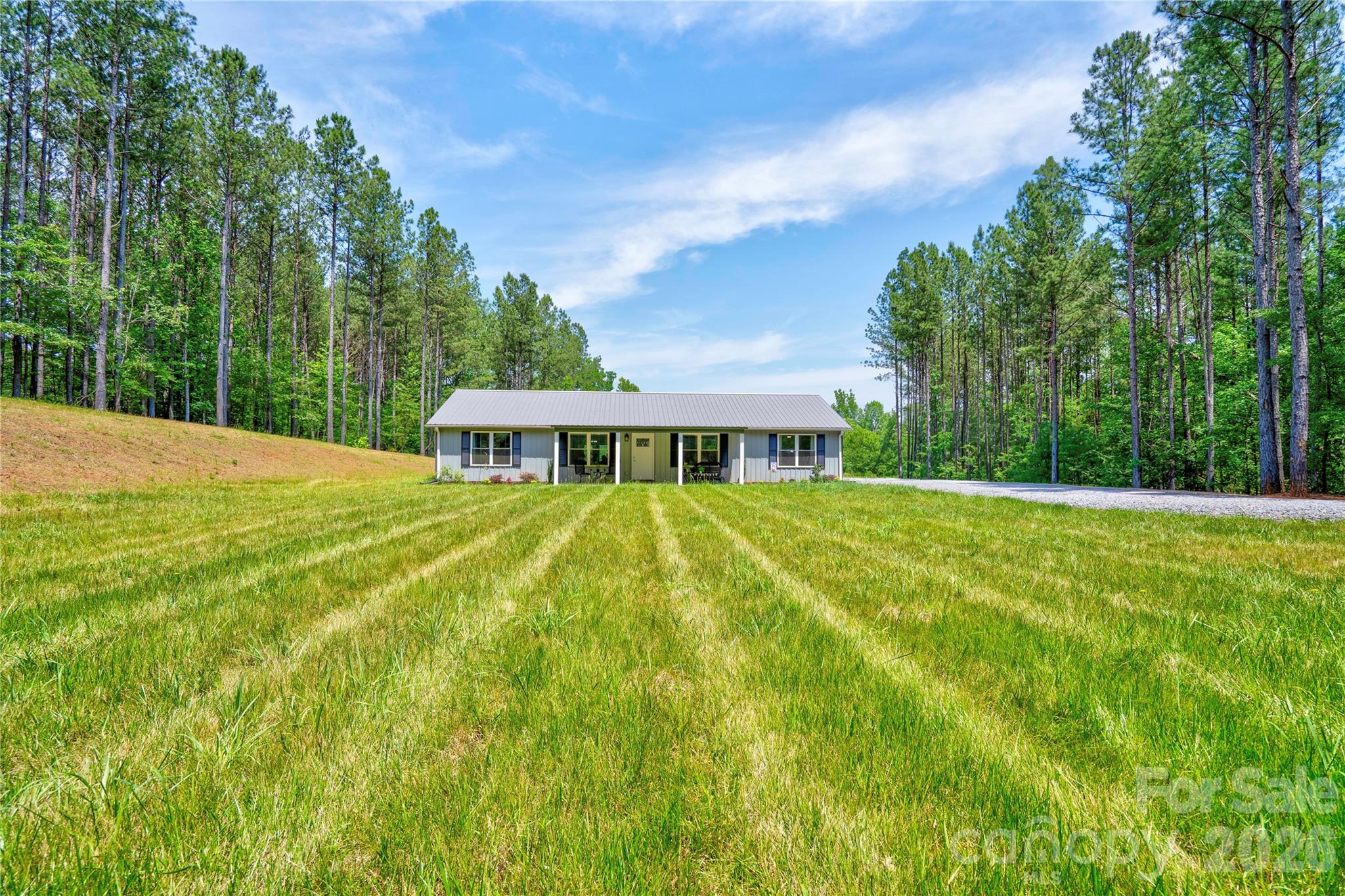 Tucked away in the woods for added privacy, this beautiful 2-bedroom, 2-bath home offers the perfect blend of comfort and functionality. The open floor plan creates a spacious and inviting atmosphere, featuring a well-appointed kitchen with stainless steel appliances, granite counter tops, a large center island, and an impressive walk-in pantry that provides abundant storage.  The private primary suite is designed for relaxation and convenience, boasting a spacious walk-in closet with custom built-ins and an ensuite bath complete with a double vanity and walk-in shower.  Enjoy peaceful mornings on the covered front porch and entertain guests on the rear concrete patio overlooking the natural surroundings. A detached double garage with a lean-to and attic storage space offers plenty of room for vehicles, hobbies, equipment, and additional storage.  If you're looking for a home that combines modern features, generous storage, and a secluded setting, this property is a must-see!