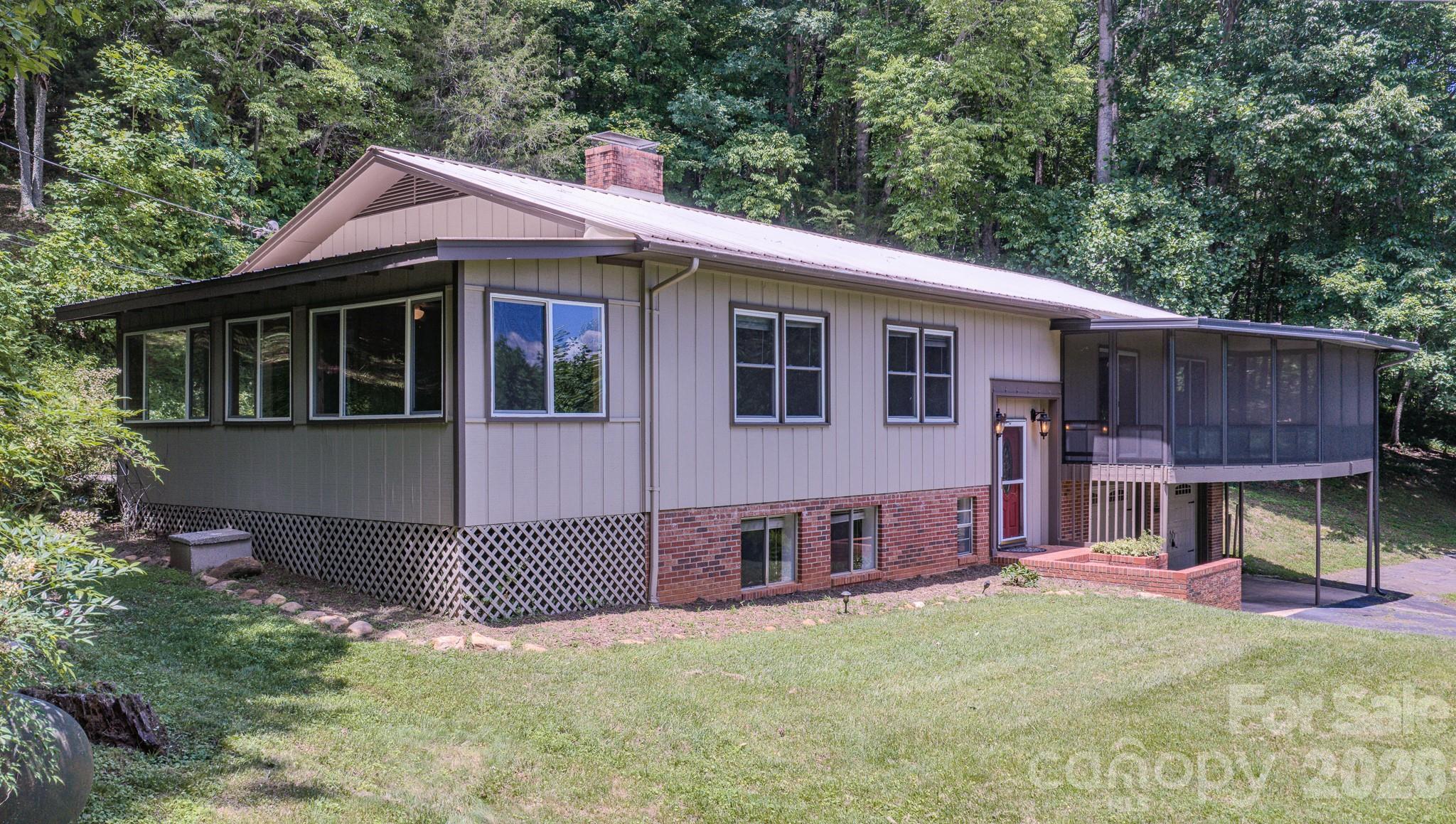 Properties like this do not come along very often. 6 buildable, contiguous lots can become your own private retreat, a homestead, a family compound or sell the unneeded lots. Freshly painted so it's move-in ready. Mountain views. Main level living. French doors in dining room to freshly stained back deck. Sliding glass doors off bedrooms to screened in, freshly stained viewing/sitting deck on the front of the house. Exterior has fresh stain. Kitchen has granite counters and backsplash, custom cabinets and a large pantry with slide out drawers. Stainless appliances. Moisture resistant, plank laminate flooring. Terrific floorplan for easy entertaining. Brick fireplace with gas logs. Spacious sunroom is just off the kitchen and also has access to back deck. Downstairs is a Family/Game room, large bonus room with closets and two windows, a full bath and large utility room for laundry and storage. Double, oversized garage. Outside is a large two-story building with electric. The lower level has storage and the second floor has a semi-finished room with lights and it's own deck. Add a mini-split & it can be an art studio, a workshop, a playhouse, etc... Chicken coop with concrete flooring and fencing is ready for your homestead's chickens. Upper lot has a well installed and potential incredible views with tree removal. On the 1.46 acre property is an small concrete building, but the roof has fallen in. No value added. Driveway is mowed all the way to the top lot.