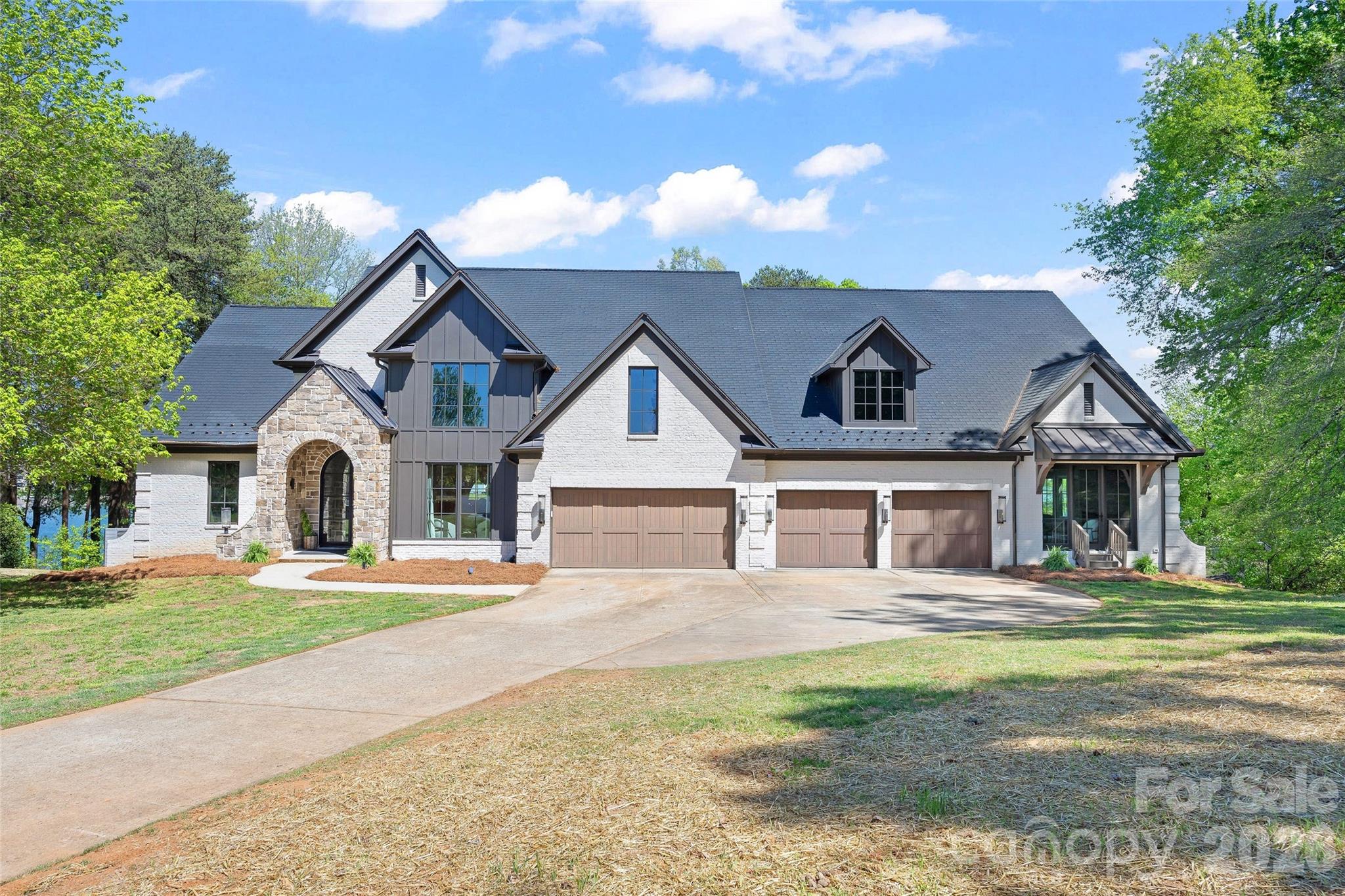 Discover unparalleled luxury and waterfront living at 20107 Bascom Ridge Dr in Cornelius, NC. This completely reimagined masterpiece is a testament to sophisticated design and meticulous craftsmanship, offering over 7000+ square feet of refined interiors, 1,300 square feet of expansive deck space, and 300 feet of pristine shoreline—a true waterfront sanctuary. Imagine designing your own private dock to perfectly complement this stunning estate and fully embrace the waterfront lifestyle. At the heart of this exquisite home lies the Chef’s Kitchen and Gourmet Scullery, a dream for culinary enthusiasts. Outfitted with professional-grade Monogram appliances, including a 48" Dual Fuel Professional Range and custom-built range hood, it’s a space where form meets function. The dual White Oak kitchen islands, bespoke Gus Cabinets with scalloped and fluted details, and an integrated 30" refrigerator and freezer elevate the space to unparalleled elegance. A Butler’s Scullery, complete with its own dishwasher, adds an extra layer of convenience for entertaining on any scale. Throughout the home, custom details evoke a sense of timeless luxury. Wide-plank White Oak hardwood floors stretch across the living spaces, accented by designer lighting at every turn—from grand chandeliers in the foyer and living room to gas-powered copper lanterns illuminating the exterior. The Primary Suite is a private retreat, featuring custom tambour-door vanities, Zellige tile accents, and a spa-inspired design that invites relaxation. Every secondary suite is a study in individuality, with bespoke vanities and curated lighting. This home isn’t just about beauty—it’s smartly designed for modern living. A private elevator effortlessly connects all levels, ensuring ease of access for everyone. The unfinished basement offers endless possibilities, whether you envision a state-of-the-art home theater, a personal gym, or additional living quarters. With this blank canvas, the opportunity to customize and expand your living space is yours to seize. Beyond aesthetics, this home offers the ultimate in modern functionality. Four new gas furnaces, dual tankless water heaters, and fully updated electrical and plumbing systems ensure seamless comfort year-round. The exterior is equally impressive, boasting a new mahogany front door, copper roofing, and fiber cement siding. The 4-car garage, adorned with elegant gas lanterns, is the perfect finishing touch. Additional lifestyle features include an executive office, entertainment bars on both levels, a custom dog room, and ample space for hosting and relaxing. Whether you're savoring the waterfront views from the deck or enjoying the finest finishes indoors, this home is designed for effortless luxury. Opportunities like this are rare—a completely renovated waterfront estate where timeless design meets modern sophistication. With the added bonus of pool renderings. Don’t miss your chance to own this one-of-a-kind property and experience the pinnacle of lakeside living.
