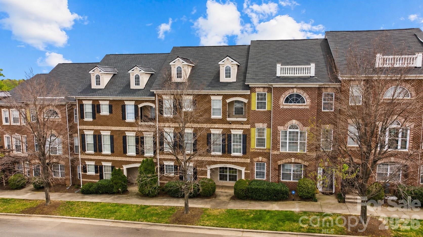 Welcome to one of the most sought-after homes in Avenues at Ayrsley—offering the largest floor plan available and an unbeatable location just steps from restaurants, shops, pubs, entertainment, and a movie theater.
This stunning full-brick, three-story townhome features 4 bedrooms, generous living spaces, and timeless architectural details throughout. Hardwood floors span the first two levels, creating warmth and character from the moment you step inside. The spacious living room is anchored by a beautiful stacked stone gas fireplace, making it the perfect place to relax or gather with friends and family. Designed for both everyday living and entertaining, the gracious dining room flows seamlessly into the chef-inspired kitchen featuring 42" cabinetry, granite countertops, stainless steel appliances, and a charming Juliette balcony. Just off the kitchen, a versatile flex space with a built-in alcove offers the perfect spot for a home office, coffee bar, beverage station, or reading nook. The oversized primary suite is truly a retreat, complete with a private covered porch, expansive walk-in closet, and a luxurious spa-like bath featuring a garden tub, separate shower, and an enormous double vanity. Walk-in closets are abundant throughout the home, providing exceptional storage and functionality. A unique and valuable feature of this home is the existing elevator shaft, which was professionally closed off and floored on the second and third levels to create additional walk-in closet space. For buyers seeking enhanced accessibility or long-term convenience, the shaft offers the potential to be converted back into a functioning elevator.Additional highlights include an oversized two-car garage with two dedicated storage closets, spacious secondary bedrooms, and a flexible floor plan that offers room to grow, work, and entertain.