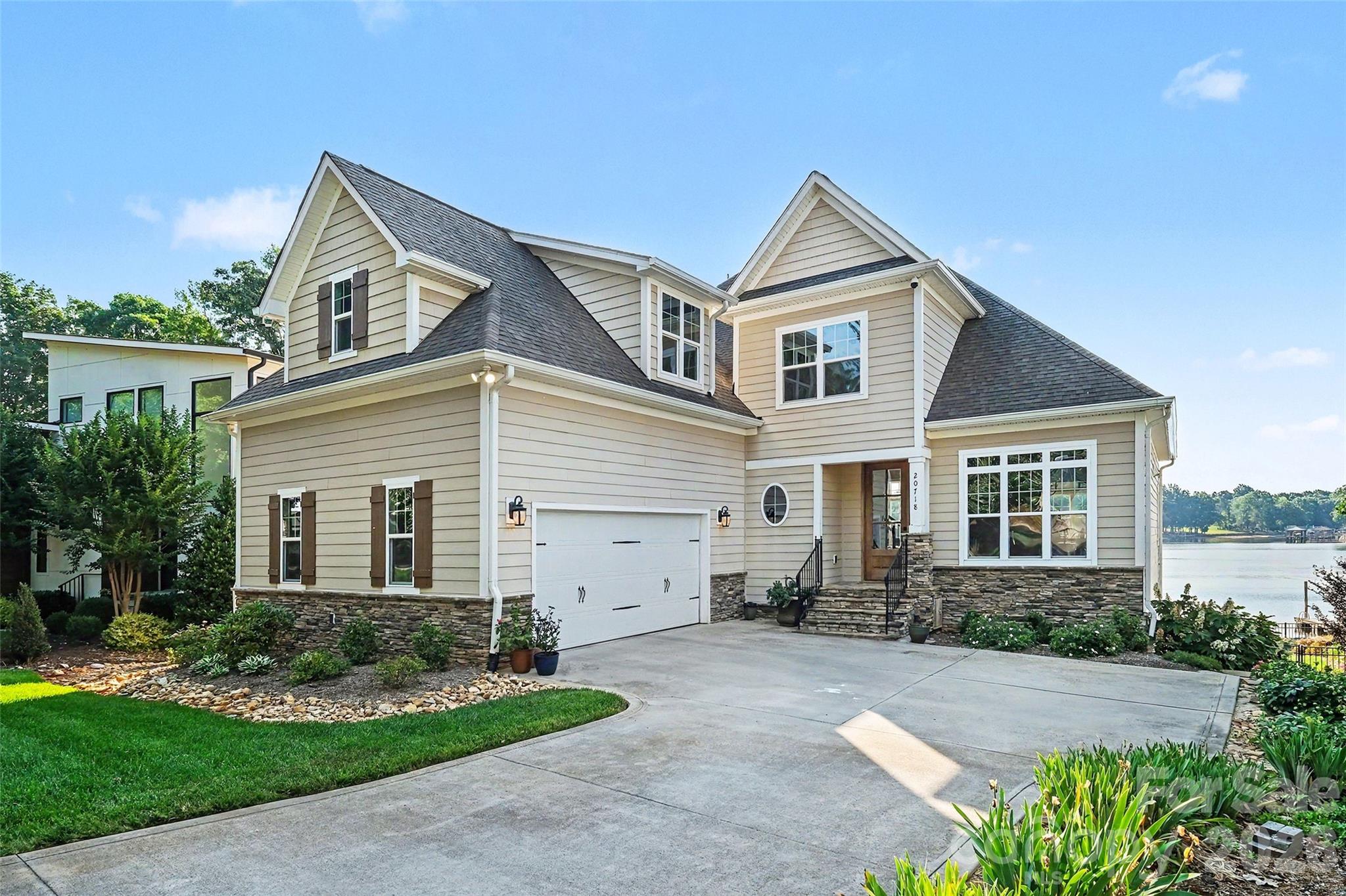 Waterfront living in this exceptional four-story Lake Norman retreat, built in 2016 and nestled within the charming Island Forest community of Cornelius, North Carolina. Offering approximately 3,775 square feet of thoughtfully designed living space, this beautifully crafted lakefront residence features four bedrooms, five bathrooms, elegant five-inch wood flooring, and breathtaking water views throughout.

Designed to balance luxury, comfort, and functionality, the home offers an ideal layout for entertaining, multigenerational living, and everyday lakeside enjoyment. The walk-out lower level serves as an impressive recreation and entertaining space complete with a custom bar, full bath, and a secondary kitchen featuring a full-size refrigerator, dishwasher, and generous storage, all seamlessly connected to the outdoor waterfront setting.

The main living level showcases an inviting open-concept design filled with natural light. A spacious family room centered around a cozy fireplace flows effortlessly into the dining area and gourmet kitchen. The custom-designed kitchen highlights premium craftsmanship with quartz countertops, a farmhouse sink, gas cooktop, double ovens, and built-in organizational storage. Also located on the main level is a luxurious primary suite offering a peaceful retreat with a spa-inspired bath, along with a well-appointed laundry room and an expansive lakeside deck perfect for outdoor dining, entertaining, and capturing stunning sunset views over Lake Norman.

The third level features two spacious bedrooms, a full bath with double vanities, and a large loft ideal for a media room, home office, or additional gathering space. The private fourth-floor suite offers an oversized bedroom with its own en-suite bath, providing exceptional flexibility for guests or extended family accommodations.

Outdoor living fully embraces the sought-after Lake Norman lifestyle with a private dock and boat lift providing direct access for boating, paddleboarding, kayaking, and year-round waterfront recreation. Residents of Island Forest also enjoy exclusive access to a gated community lot featuring a private boat ramp and pier, all complemented by a remarkably low annual HOA fee of only $95.

Conveniently located near premier waterfront dining, boutique shopping, parks, marinas, and local amenities, this remarkable property combines elegant design, expansive living spaces, and an exceptional waterfront setting to deliver the ultimate Lake Norman luxury lifestyle.