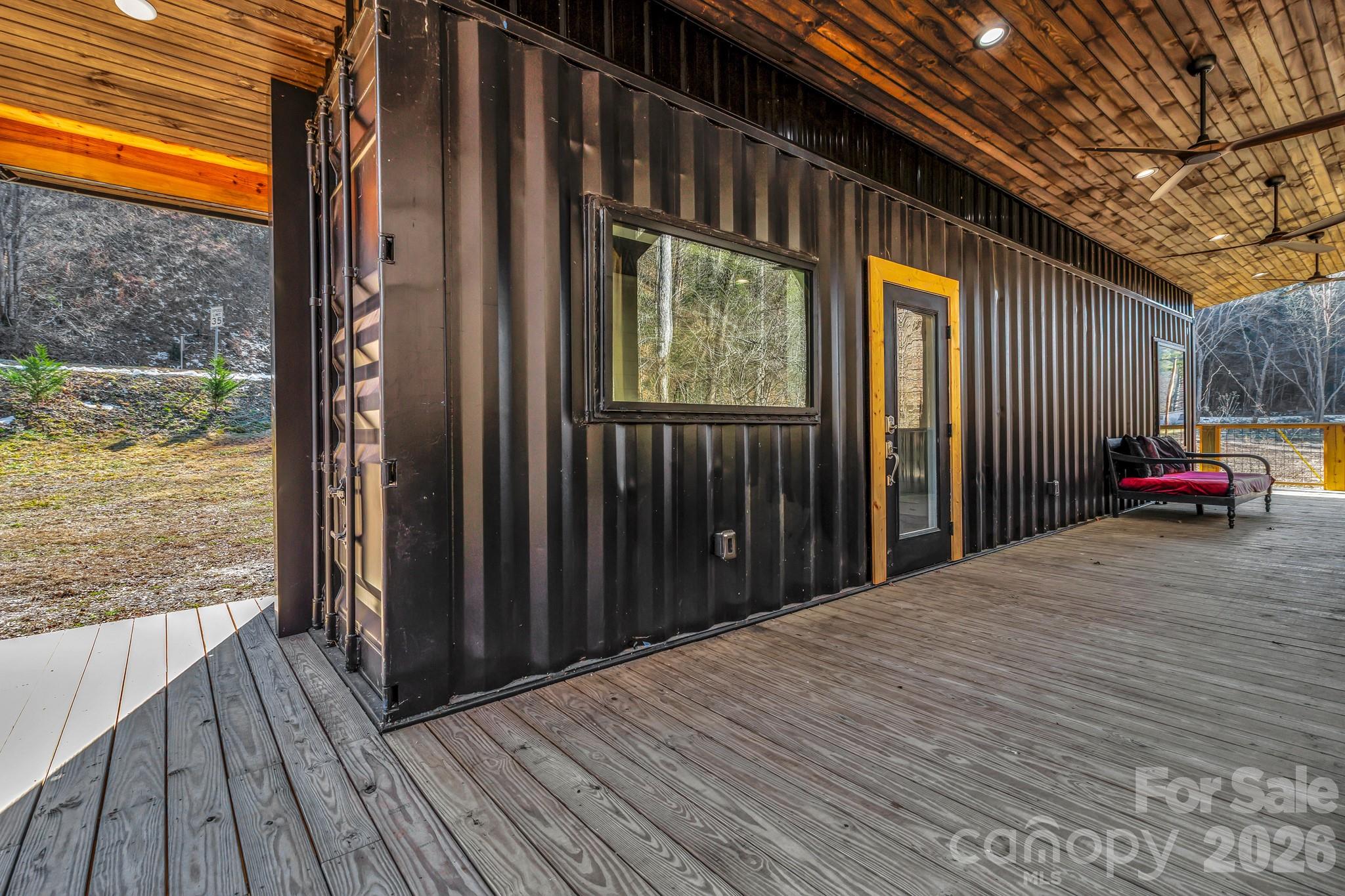Welcome to this thoughtfully designed custom built container home offering modern efficiency and peaceful surroundings on .94 acres overlooking a beautiful creek. Fully built out and move-in ready, this unique property features a full kitchen, full bathroom, and private bedroom — maximizing every inch of space with smart design and quality finishes.

The kitchen is equipped with premium Big Chill appliances including an induction range, refrigerator, and freezer, blending style and performance in a compact footprint. Large windows invite natural light and bring the outdoors in, creating a bright and inviting atmosphere.

One of the standout features is the expansive 500 sq ft covered wrap around porch overlooking the creek — the perfect place to relax, entertain, or simply enjoy the soothing sound of flowing water year-round. This generous outdoor living space nearly doubles the functional footprint of the home and creates an incredible indoor-outdoor lifestyle.

Whether you’re looking for a turnkey short-term rental opportunity or a private mountain escape to unplug and enjoy the peace and quiet, this property offers incredible flexibility. Located just 10 minutes from downtown Hot Springs, you’ll have easy access to hiking trails, local shopping, great dining, and the area’s famous natural hot springs, all while being within an hour’s drive to larger cities like Asheville, NC and Knoxville, TN where you can enjoy even more dining, music and brewery options. 

Small footprint. Big experience. Rare opportunity.