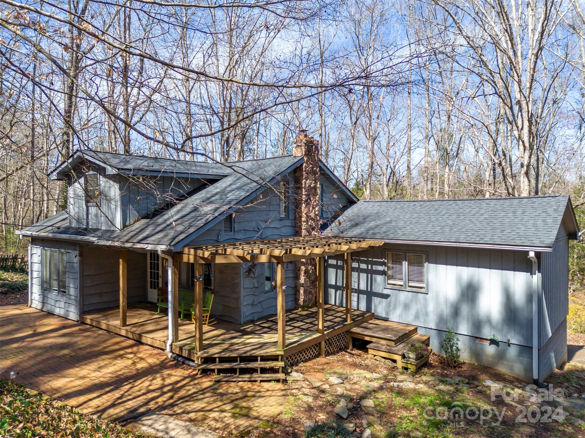 Nestled in a serene neighborhood, this delightful cottage offers a blend of comfort and convenience. Situated on 3.71 acres gives you the sense of peace and tranquility.  This home offers spacious rooms, wood floors, kitchen with center island and beaded board cabinets, living room with a propane fireplace, office area off of the primary bedroom, main level primary ensuite w/vaulted ceiling, walk-in closet & full bath. Upper level hosts 2 guest bedrooms and a full bath.  There is plenty of storage, laundry area in the basement and an opportunity to expand living space. Whether you're hosting summer barbecues or enjoying a quiet morning coffee, this outdoor space is sure to impress with expansive covered porches to enjoy the outdoors. Located just off of Peniel Road in Tryon you can be over to 26 or Hwy. 9 and 74 in just minutes.