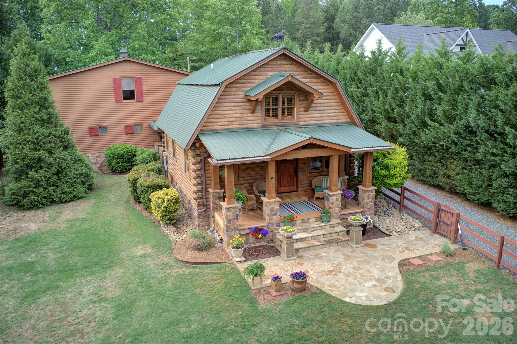 Dear prospective buyer, what we have here is a rare gem of a true log cabin on nearly an acre in Davidson with over 1700 sq. ft. of garage/storage/customizable space. You'll quickly come to see this is less about the cost per square foot, and more about the lifestyle and experience the property offers. Almost every inch of the property has been touched and improved by current owners. They have upgraded, enlarged, planted, and created a private shady oasis unlike anything you've seen in Davidson to date. Take note of everything this one-of-a-kind property already offers: private gated entry; covered front and back porches; a stacked stone fireplace out back; a newly remodeled kitchen; updated bath; upgraded flooring, plantation shutters; fully encapsulated crawl space w/dehumidifier; extensive landscaping and French drains; fenced front yard; and 2 spacious storage sheds. You can't miss the extraordinary 3-car/two-story garage (added in 2012) with half bath and laundry on main, and the potential for so much more on 2nd level. The unfinished 864 sq. ft on the second level is a blank canvas for you to "paint." I would be remiss not to mention one of the best areas of this property - the 673 sq. ft of covered outdoor living spaces- back and front porches - where you will most likely find a breeze. Seriously, how often do have the opportunity to live in the country and literally walk to your local country club swim and tennis center or enjoy a meal at Slice Cafe? River Run CC memberships are available. You're not just buying a home — you're buying into Davidson's next great chapter. Have you heard of Summit Farms? The most buzzed-about development in the region is proposed just a block away. This 62-acre farm-to-table village from the Summit Coffee team will bring an organic farm, roastery, bakeshop, and farm-to-table dining just a few steps away once complete. The house you've driven by hundreds of times and always wondered about could now be yours. Are you considering a lifestyle change? Schedule your appointment today to see THE CABIN. We respectfully ask that you please do not drive up the driveway without an appointment with your broker.
