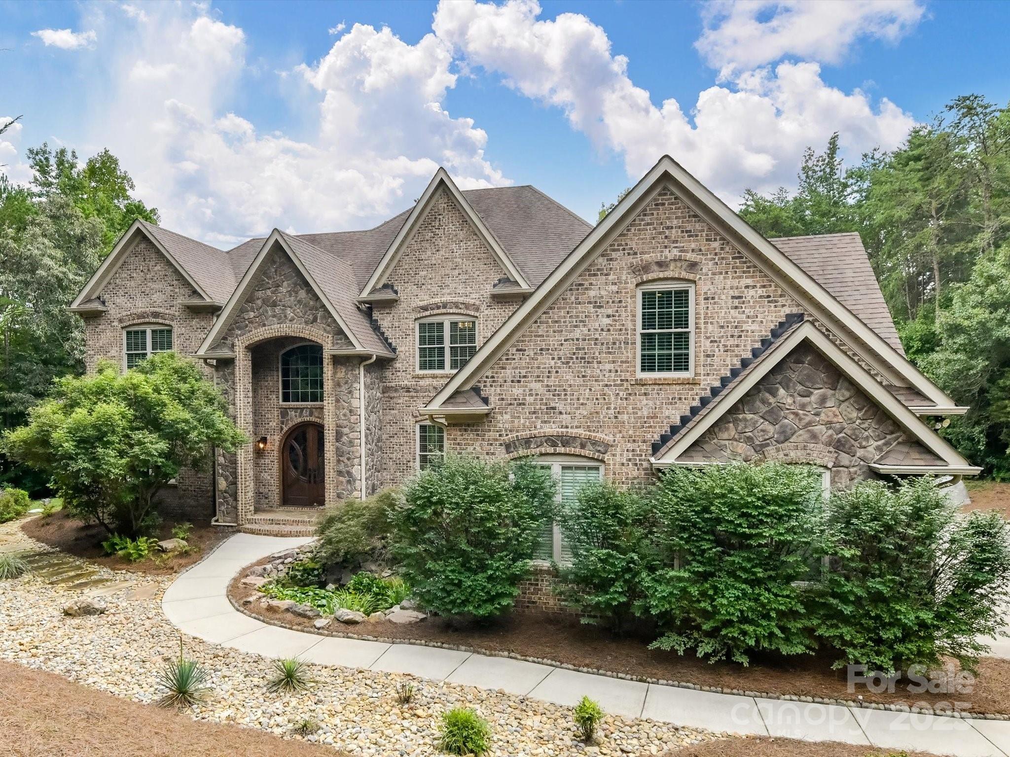 Welcome Home to this stunning property crafted by Oz Custom Homes. On just over two private acres, in sought after Fort Mill, this 5-bedroom, 7-bath residence balances timeless design with modern innovation. Inside, soaring ceilings and hardwood floors set the stage for a home filled with thoughtful details at every turn. The chef’s kitchen with a hidden pantry and Thermador appliances. It opens seamlessly to inviting gathering spaces. Design details include a private office with a clever passageway, spacious game room, luxurious primary suite with heated bathroom floors and a custom closet. Flex room on the main level can be a guest suite, exercise room or additional office. Outside, the stunning covered porch overlooks a private oasis with a saltwater pool and spa, framed by professional landscaping, stone patio, outdoor grill, and a firepit. A beautiful koi pond in the front sets the stage for privacy and elegance. Smart technology, solar energy, whole-home systems for efficiency, and comfort-driven upgrades enhance every corner, making this home a perfect blend of luxury, convenience, and innovation. This is more than a house, it’s the setting for your next chapter!
