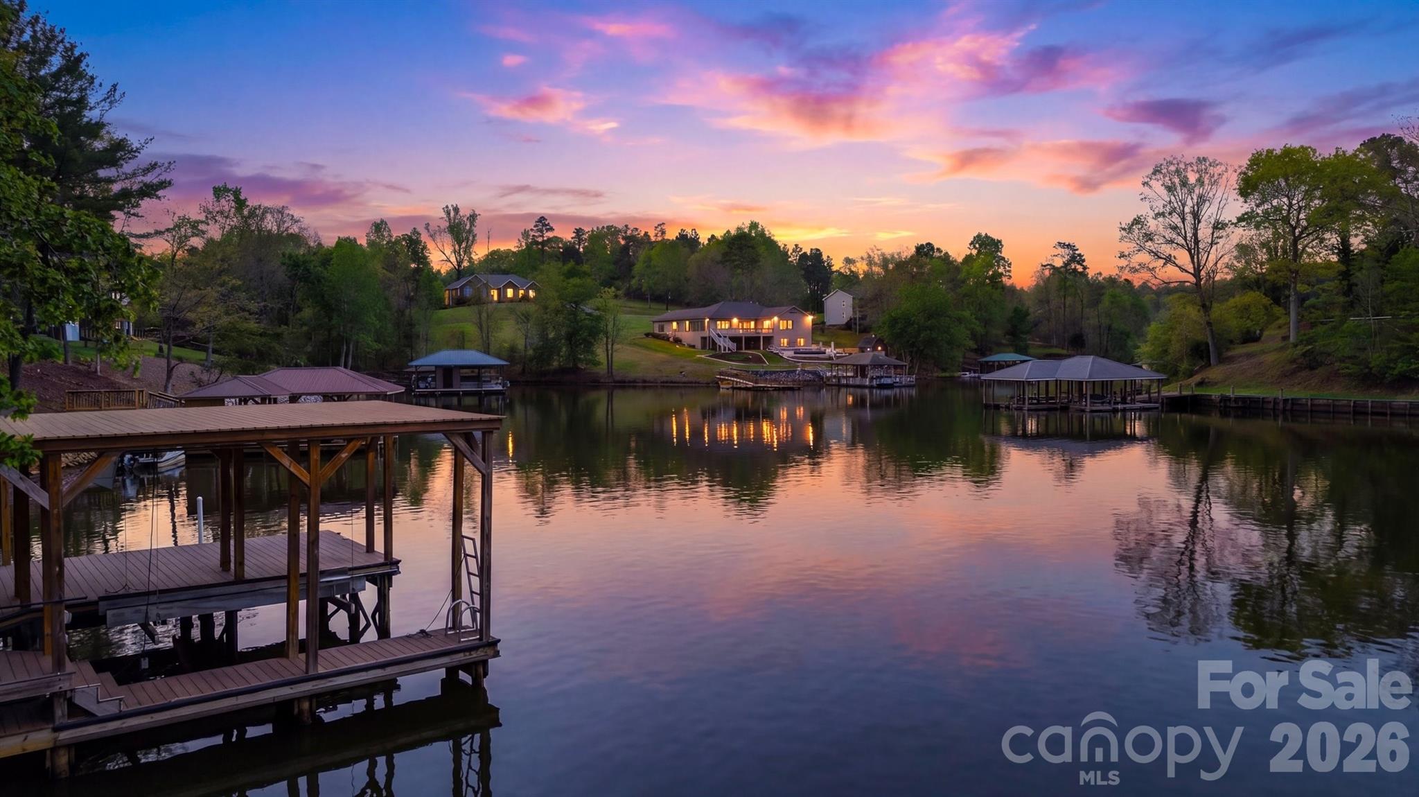Experience the ultimate in lakefront luxury with this exclusive 2-ACRE WATERFRONT PROPERTY offering unparalleled privacy. Enter through the stately IRON GATE and follow your future private drive to the your personal lakeside retreat.  This exceptional homesite features 131 FEET OF SHORELINE, a CLEARED BUILDING SITE with SILT FENCE in place, 4 BEDROOM SEPTIC PERMIT, SHORELINE STABILIZATION permit, SAW SERVICE available for connection, and a CUSTOM TWO-STORY BOAT DOCK with DOOZI Boat Lift and jet ski ramp. Architect designed and engineered stamped house plans are available for an additional cost for a 4 Bedroom Saddleback-style residence designed to embrace the water views from every vantage point!  3 of the 4 bedrooms are suites.  The plans were designed with an elevator shaft and a toy garage suitable for a golf cart! There is more than enough room on the property for a 4 car garage/workshop. The land is ideal for entertaining, relaxing, or enjoying the tranquil sunsets that paint the water each evening. The building site is positioned to take advantage of the magnificent views of the expansive shoreline and serene natural setting, this rare property provides the perfect canvas to design your dream estate. A TRULY ONE-OF-A KIND OPPORTUNITY  to own a premier piece of lakefront paradise.  Enjoy North Carolina's 4 SEASONS!!  Spend the weekends on the lake & visit the NC Mountains in your spare time!!!  A little over an hour to Charlotte Douglas Airport!  Please be sure to watch the linked video!!!