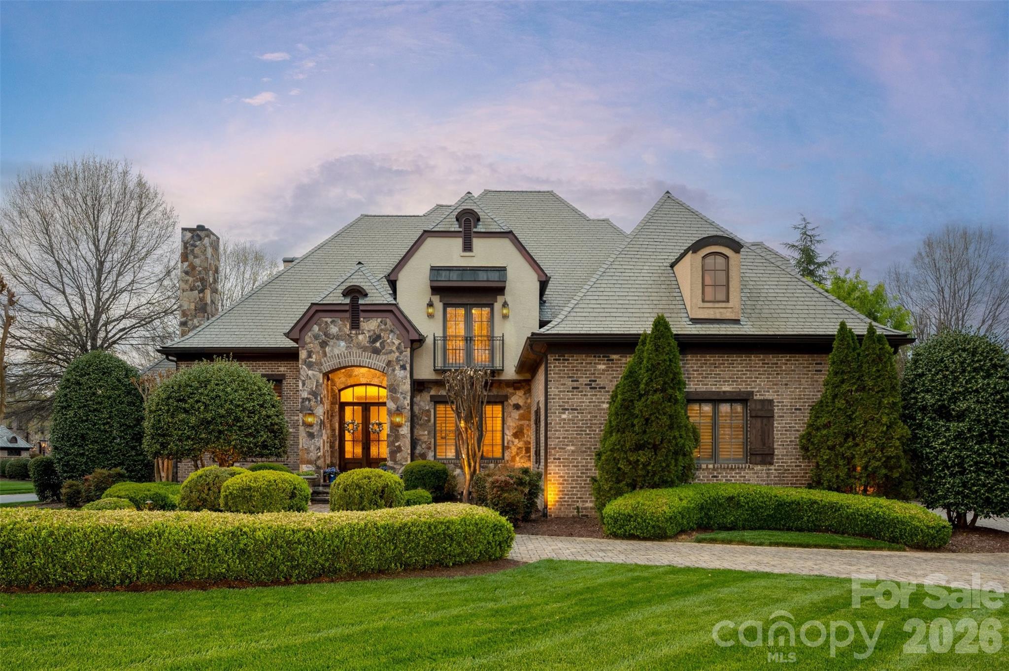 Located in the prestigious estate section of Longview Country Club, this exceptional residence showcases the same high level of craftsmanship and architectural detail found throughout the community—perfectly positioned on a private, fenced ½-acre lot with a circular driveway.

Inside, timeless elegance meets everyday functionality. A richly appointed office features detailed wood paneling, a coffered ceiling, and a striking stone fireplace, while the formal dining room impresses with classic wainscoting. Plantation shutters throughout add both charm and sophistication.

The open-concept layout is designed for effortless living and entertaining. A light-filled kitchen offers granite countertops, a center island, and stainless steel appliances, flowing seamlessly into the family room and breakfast area, with direct access to a screened-in side porch. A cozy keeping room overlooks the private backyard, creating an inviting space to relax. With three fireplaces throughout the home, warmth and ambiance are always within reach.

The spacious primary suite is a true retreat, complete with separate walk-in closets, a soaking tub, dual vanities, and plenty of room to unwind. Upstairs, three generously sized secondary bedrooms each feature their own private en-suite baths, offering comfort and privacy for family or guests.

Entertainment and flexibility abound with a fully equipped home theater featuring a projector, along with additional flex space ideal for a gym, craft room, or second office.

Fully fenced, private backyard features a covered pavilion with a large lounging area and gorgeous outdoor wood burning stone fireplace.

Residents of Longview enjoy a premier lifestyle with access to an 18-hole Jack Nicklaus signature golf course, dining, fitness center, pools, tennis, and a youth lodge. 

Refined living in one of the area’s most sought-after communities.