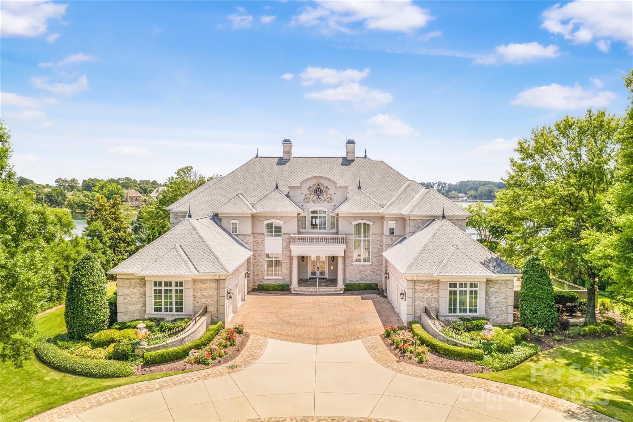 Breathtaking views from Sunrise to Sunset! Enjoy luxurious lake living at this address featuring 2 docks, boat lift, covered dock area, sandy beach, firepit, putting green, beautiful infinity pool & hot tub. Plenty of room for entertaining indoors & out. Billiard room features wet bar, dart board, sunken couch, projector screen & floor to ceiling windows of lake views! Gourmet kitchen features Wolfe stove, double ovens, 2 dishwashers, island has charging stations & lake views. Bedroom on main for guest-full bath, sauna shower & private garden. Upstairs features owners suite-wonderful lake views & walk out to 2nd level patio & fireplace. Owners bath, a must see. 4 more bedrooms upstairs all have private baths. One office off owners suite also serves as lovely sitting area w/access to outdoor patio & one adjacent to bedroom. Half way up stairs features a panic room w/vault door. Third floor level is finished-perfect area for theatre room & bar. All new lighting throughout the home.
