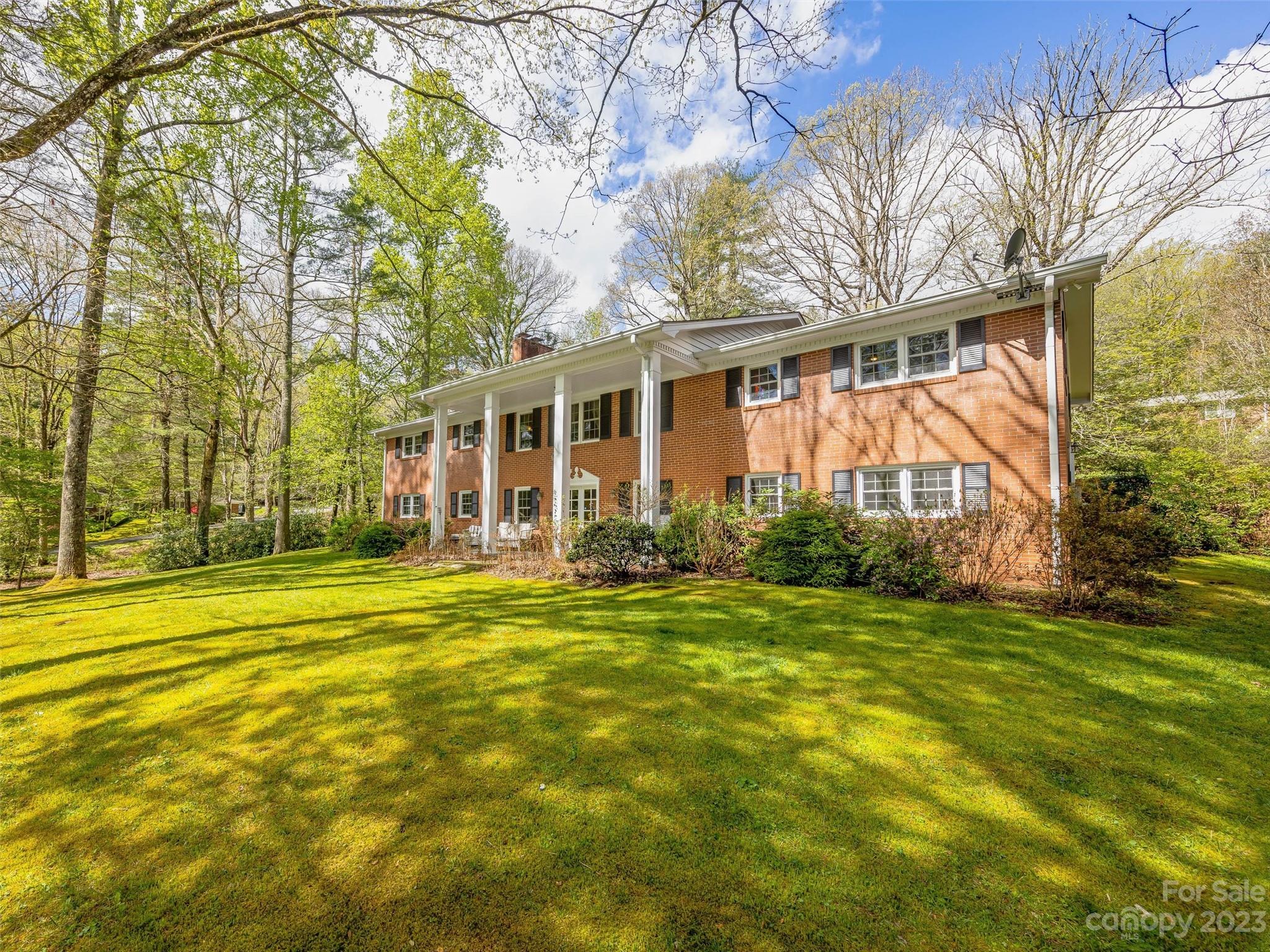 Own a piece of North Carolina history. Ravenswood is located in historic Flat Rock, bordering the Carl Sandburg estate and across the street from The Flat Rock playhouse. This 4,386 sf home is spacious, well-maintained, and situated on a large cleared lot filled with beautiful foliage. The main floor of the home includes the kitchen, dining room, living room with fireplace, master bedroom with ensuite bathroom, two more bedrooms, a full bathroom, and a bonus room that comes off of the two-car garage. The lower level basement is a full walkout with entrances on three sides and contains a bar area, large living room with a fireplace, large laundry room, another bedroom with an ensuite bathroom, a half bath, and two bonus rooms. The heated and cooled bonus rooms can be used as a fitness room, office space, playroom, studio, etc. Ravenswood has a private lake that can be used for non-motorized recreation by residents only. High-speed internet is installed. Roads are publically maintained.