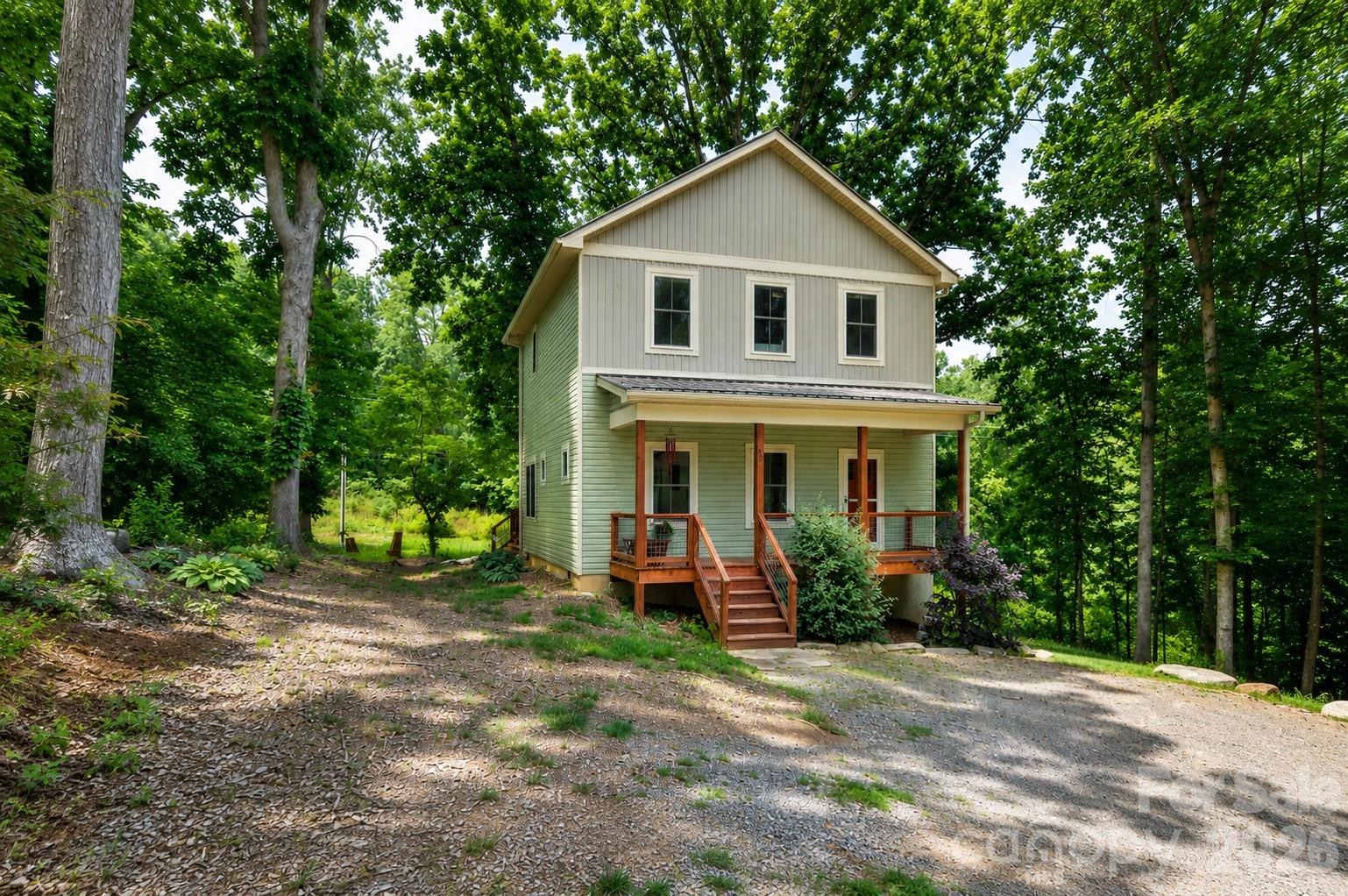 Tucked back from the road on a 0.74-acre lot in Candler, this 2021-built home offers a peaceful setting just minutes to Biltmore Lake walking trails, Smoky Park Highway grocery stores and restaurants, the Candler YMCA, and only 20 minutes to downtown Asheville. Relax on the covered front porch, gather around the professionally built rock fire pit, or enjoy the back deck overlooking the wooded backyard. Inside, the bright open floor plan features abundant natural light, LVP flooring throughout, and a stylish kitchen with stainless steel appliances and an eat-in island. All bedrooms are upstairs, including the spacious primary bedroom with a walk-in closet and an ensuite bathroom. Low-maintenance living with great storage, lovely landscaping, Enka schools, and potential rental flexibility in this Buncombe County location (buyer to verify).