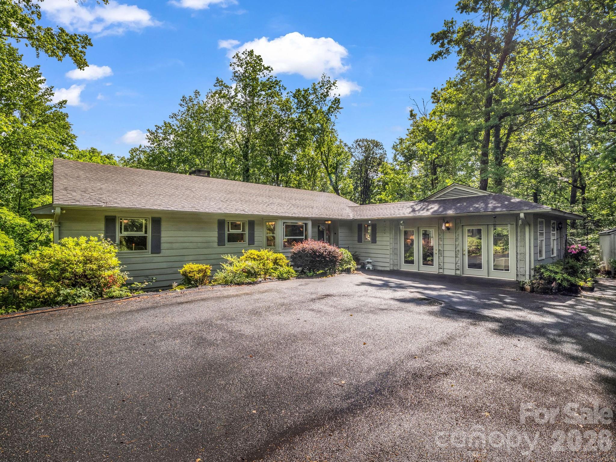 Tucked away on 2.2 private wooded acres in beautiful Tryon, this Country Living magazine–inspired home offers space, charm, and endless potential. A peaceful stream winds along the backyard, creating a serene setting perfect for enjoying nature and the privacy of this unique property.

Inside, you’ll find a spacious and flexible floor plan featuring 4 bedrooms and 3.5 baths with room for everyone to spread out. The upper-level features 2 bedrooms, 2 full baths, a dining room, spacious living room, functional kitchen, cozy sitting area, and a bright sunroom filled with natural light. The finished basement offers 2 additional bedrooms, another flex room, a den, and a second sunroom—ideal for guests, multigenerational living, hobbies, or home office space. A bonus room on the main level includes its own mini-split system for efficient heating and cooling.

Surrounded by mature trees and natural beauty, this home is full of character and opportunity for the buyer ready to make it their own. Exterior siding does need attention, and the home is priced accordingly. An estimate from a contractor for the siding repair is available for serious inquiries, offering added transparency and helping buyers envision the incredible potential of this private mountain-area retreat.