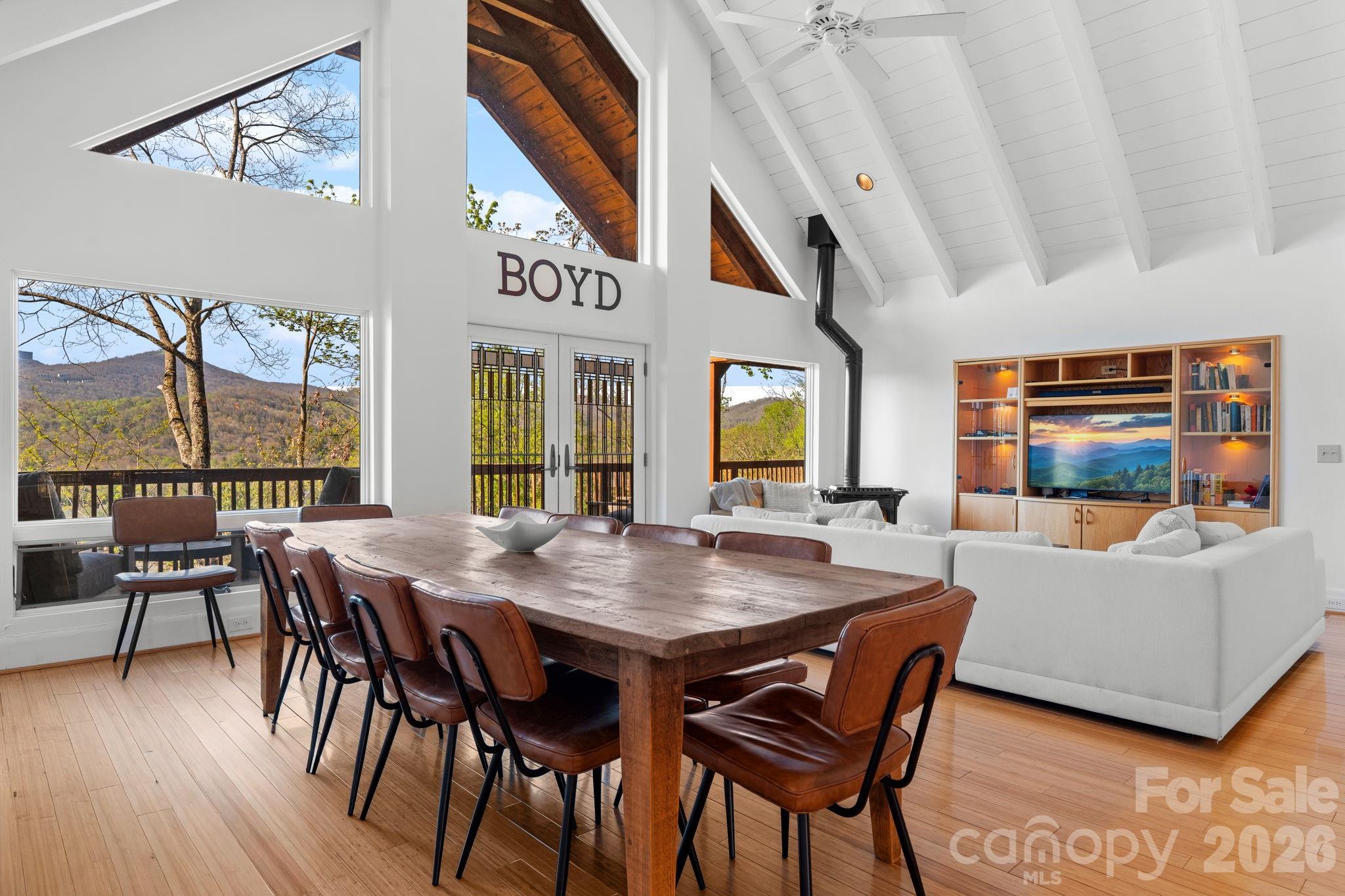 Perched just above the charming town of Banner Elk, this spacious home delivers the best of mountain living — peaceful enough to hear the leaves rustle, yet close enough to hear the music drifting up from the town park on Thursday summer evenings. In winter, skiing at Sugar Mountain and Beech Mountain awaits just 15 minutes away. Year-round, downtown Banner Elk's shops and restaurants are less than half a mile from your door. Arrive to ample parking and take just four easy steps up to the main level — single-level living if desired. The full-length rocking chair front porch sets the tone immediately, welcoming you to the mountains. Step inside to soaring vaulted ceilings and an open-concept living, dining, and kitchen area finished in a white-washed style that brings a fresh, modern feel. The kitchen offers a generous island with breakfast bar seating. There is a comfortable living area and a large dining table to seat everyone. And yes, the home is offered fully furnished, with just a few exceptions. The main level follows a split floorplan. On one side, the spacious primary suite features a bright, beautifully renovated bath and en-suite laundry — plus direct access to the full-length back deck, where views over the town of Banner Elk await. On the other side, two additional bedrooms each open to the front or back deck, and share a well-appointed bath. Every bedroom is genuinely spacious; no one draws the short straw here. The lower level offers tremendous flexibility — a huge living area, a fourth bedroom with seating area, and two full baths give guests or family members a retreat of their own- including a separate entrance from the driveway. On the lower back deck, you’ll find a concrete slab and wiring already in place for a hot tub. The oversized, attached two-car garage opens to this level. The owners have taken exceptional care of the home: a new roof (2019), sanded and stained (2020), new retaining wall and 1,000 gallon propane tank (2020), repaved driveway (2022), new water heaters (2026), a new A/C compressor (2026), and more! No HOA, and the home is on city water and sewer and a city maintained paved road. This home is move-in ready and built to last. Whether you're looking for a full-time mountain home, a vacation retreat, or an income-producing rental property, this home checks every box. When you can't be here — and you'll always wish you could — the rental potential is excellent.
