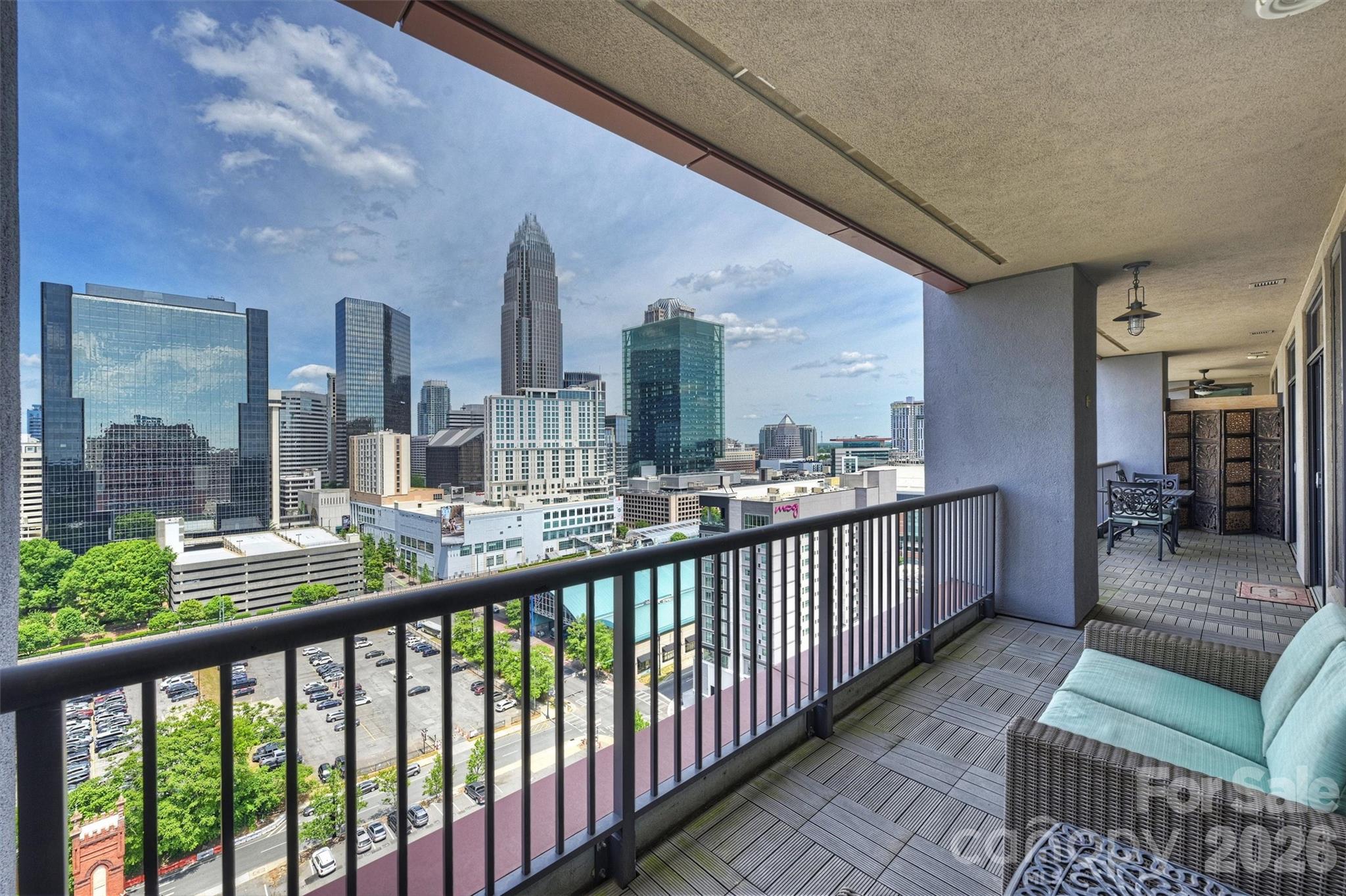 Experience the best of Uptown living at SKYE Condominiums. Enjoy spectacular skyline vistas and unforgettable sunsets, with dinners at Fahrenheit just upstairs, and shows at the Blumenthal or games at Spectrum Center only moments away. Easy access to the streetcar and light rail connects you to South End, Elizabeth, and NoDa for dining, shopping, and entertainment. This modern and stylish 2-bedroom, 2-bath condo offers 1,203 square feet of open, light-filled living space, plus a 231 square foot balcony that lives like an additional room. Expansive windows, hardwood floors, and UV shades by Smith & Noble enhance both comfort and design. The custom-designed kitchen features KitchenAid stainless steel appliances, a 16-gauge Porcher London farmhouse sink, self-closing cabinetry, granite countertops, and a contemporary glass backsplash. The primary suite offers a spa-like retreat with an oversized shower with rain head, Calacatta marble tile floor, and an Italian mosaic inset. Additional highlights include two assigned parking spaces, a storage unit, and the convenience of an on-site hotel that is perfect for hosting guests. The building amenities include a fitness center, game room, theater room, and owners' suite. The HOA dues cover nearly all monthly expenses, including HVAC, gas, and water. Elevated, effortless, and in the middle of it all; this is Uptown living at its finest.