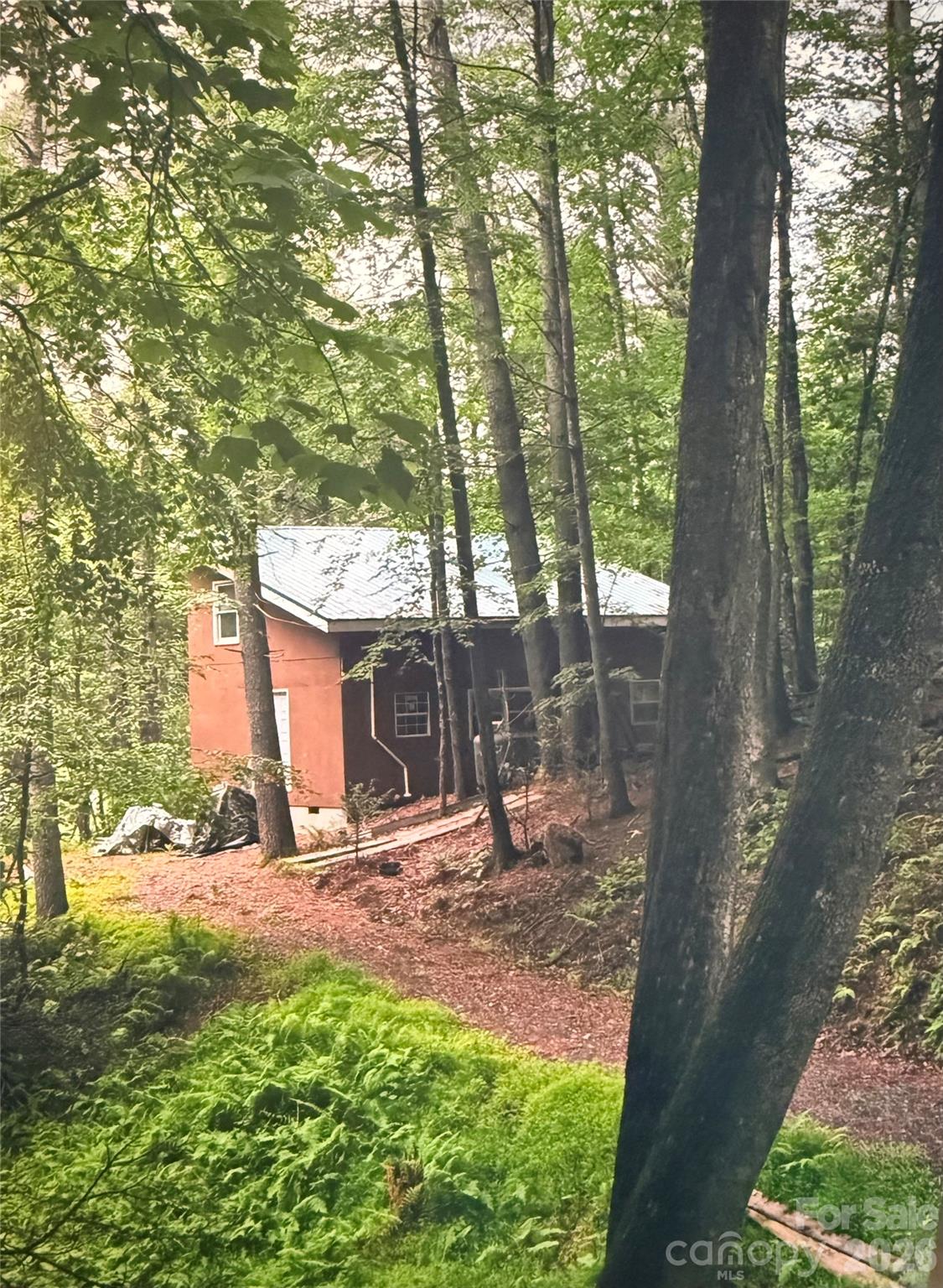 (PART OF ASHE COUNTY PARCEL ID 122994122127 TBD APPX. 5 ACRES).....Unbelievable opportunity to obtain a truly unique high country mountain property. TBD Approximately 5 acres with historic "1919"  rough sawn lumber built house and outbuildings, located only about 425' from the historic New River, and about three miles from the Blueridge Parkway access, ("shorter" as the crow flys). The Approx. 5 acres will be Surveyed off to define boundaries prior to Deed development.  Ashe County New River Access Park is directly across the river from this property, where you can launch kayaks, canoes, tubes and floats on the popular shallow, clean New River.  The house is shown on Ashe County public record as being originally built in 1919, and is framed with local rough sawn hardwood and beams.  House was designed as 32'2"x20'2" main level open room, with built in hardwood ladder up to second floor open sleeping loft appx. 32.2"x15'.  The property displays remodeling over the years, and did experience damages from Hurricane Helene, however repairs were made and new green metal roof installed.  Great opportunity for someone who values old style beam rough sawn construction and can appreciate a blank slate to renovate /make it their own.  The interior of the house has been stripped out, down to the bare wood.  See attached interior pictures.  This property borders the Bare Hollow residential development of acreage sized lots, of similar acreage size, and larger lots, and this Appx. (to be surveyed) will adhere to the same restrictive covenants, with additional deed restrictions by Seller.   House originally was served by historic artesian spring water system, with pump up to house elevation, which would need to be repaired/restored, and originally had one bathroom and small kitchen with sink, both of which have been stripped out with the Hurricane Helene damage repairs.   After Hurricane Helene damages, cleanup of the trees, renovation of the private road, with new grading and new gravel was performed so that access to this property is now readily accessible with even a conventional TWD vehicle.  Access to this property from the Bare Hollow S/D road will be by deeded easement on the Sellers private road.  The property also includes an old open shed, out buildings and personal possessions from prior owner including rough sawn lumber stacked in the open garden shed.  With acceptable purchase Offer, the Seller is willing to consider including the prior owner's two garden tractors, 16' boat, large diesel engine, Stanley wood oven/stove, Honda 250 motorcycle, large LP gas tank with appx. 60% fill, and etc. that are still stored in outbuildings.  All property and possessions will be sold "as is", and Seller extends no warranties.  For this sale, the personal possessions are considered to be of minimal /no value. The property is heavily wooded with predominately hardwood trees, and extensive Rhododendron and Mountain Laurel.  Wildlife abounds on this mountain land, with trail cameras showing visits by deer, wild turkeys, fox, opossum, raccoon, various birds, and even a porcupine.  See the attached pictures.  Area is somewhat a wildlife sanctuary, with Bare Hollow acreage development, along the New River, prohibiting hunting.  See Map for approx. 5 acres which will  be Surveyed off from parcel at time of sale. NO Homeowner’s Association and no HOA dues, Deed restrictions by Owner/Seller.