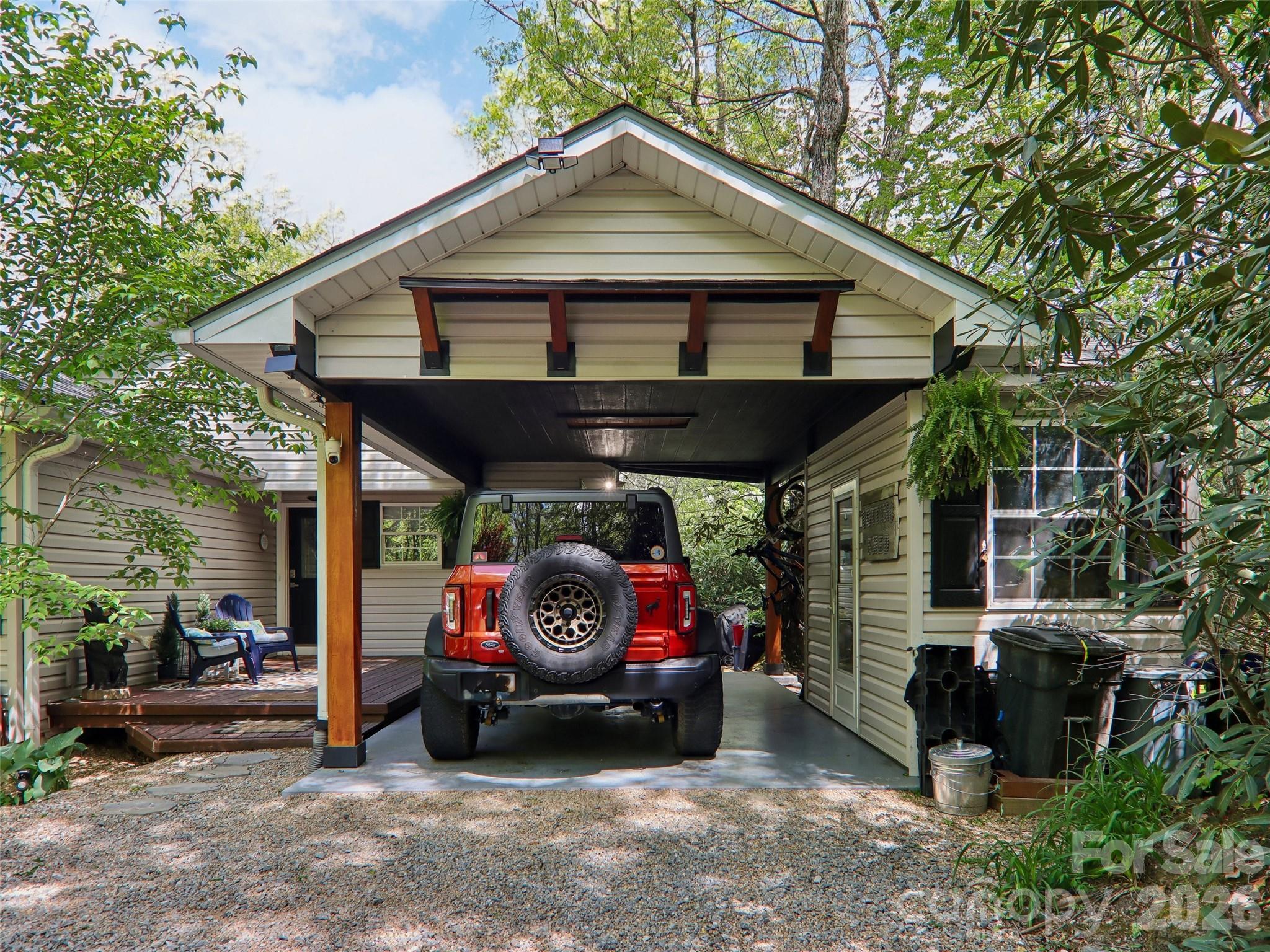 Experience the quintessential Blue Ridge lifestyle in this private mountain sanctuary, perfectly positioned just 12 minutes to downtown Brevard and 25 minutes to Hendersonville. Nestled on 1.5 low-maintenance acres, this 2,122 sq. ft. home combines rustic character with peace of mind, featuring a brand-new roof installed in 2025. The main level features a bright, open floor plan with stunning hardwood floors, a cozy stone fireplace, and two serene bedrooms designed for easy daily living. The full-daylight walk-out terrace level reveals a beautifully finished, independent guest suite with its own private entrance, bedroom, bath, den, and kitchenette—ideal for multi-generational living, long-term guests, or a dedicated hobby studio. Step outside to your private wooded ravine, where a gentle walking trail leads through mature foliage to a babbling creek and a picturesque waterfall. Relax on the back deck with crisp winter mountain views, knowing the heavy maintenance is already done. This is the turn-key, manageable mountain escape you've earned.