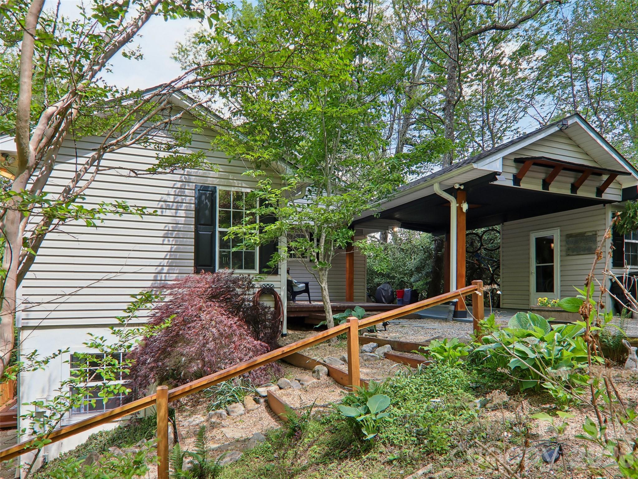 Experience the quintessential Blue Ridge lifestyle in this private mountain sanctuary, perfectly positioned just 12 minutes to downtown Brevard and 25 minutes to Hendersonville. Nestled on 1.5 low-maintenance acres, this 2,122 sq. ft. home combines rustic character with peace of mind, featuring a brand-new roof installed in 2025. The main level features a bright, open floor plan with stunning hardwood floors, a cozy stone fireplace, and two serene bedrooms designed for easy daily living. The full-daylight walk-out terrace level reveals a beautifully finished, independent guest suite with its own private entrance, bedroom, bath, den, and kitchenette—ideal for multi-generational living, long-term guests, or a dedicated hobby studio. Step outside to your private wooded ravine, where a gentle walking trail leads through mature foliage to a babbling creek and a picturesque waterfall. Relax on the back deck with crisp winter mountain views, knowing the heavy maintenance is already done. This is the turn-key, manageable mountain escape you've earned. Sellers are offering an INTEREST RATE BUY DOWN!