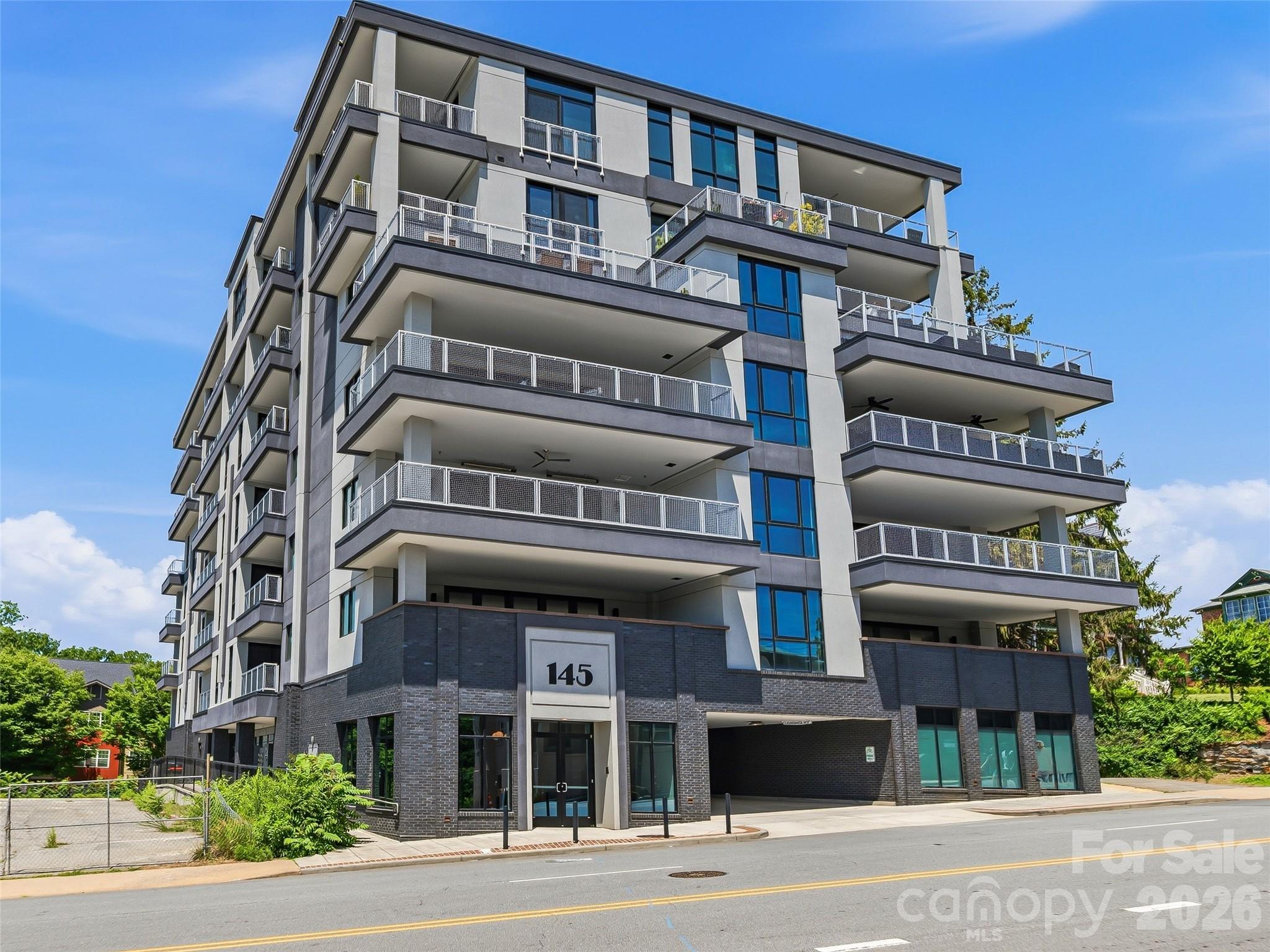 Located in a newly constructed concrete-and-steel mid-rise building, this STR PERMITTED, turn-key, fully furnished luxury condo presents an exceptional opportunity for rental income or personal enjoyment.  It also incudes dedicated parking and storage. Thoughtfully designed and impeccably maintained, the residence combines modern comfort with effortless style.

The spacious interior opens to a north facing large private balcony, seamlessly extending the living area and creating an inviting space for relaxed three-season outdoor living. Inside, the gourmet kitchen—appointed with all stainless-steel appliances and a generous island—serves as the heart of the home, perfect for entertaining, gathering with friends, or enjoying shared meals.

The layout offers a well-appointed bedroom, along with an additional sofa bed. The building itself enhances the experience with quiet corridors, elevator access, secure garage parking for one vehicle, and a welcoming lobby that leaves a lasting first impression.

Ideally situated adjacent to Asheville’s vibrant South Slope, this condo places you right in the center of downtown energy. Just two blocks from the ballpark and minutes from an array of restaurants, you’ll also enjoy effortless access to the renowned South Slope brewery district—only one block from the building’s rear entrance.