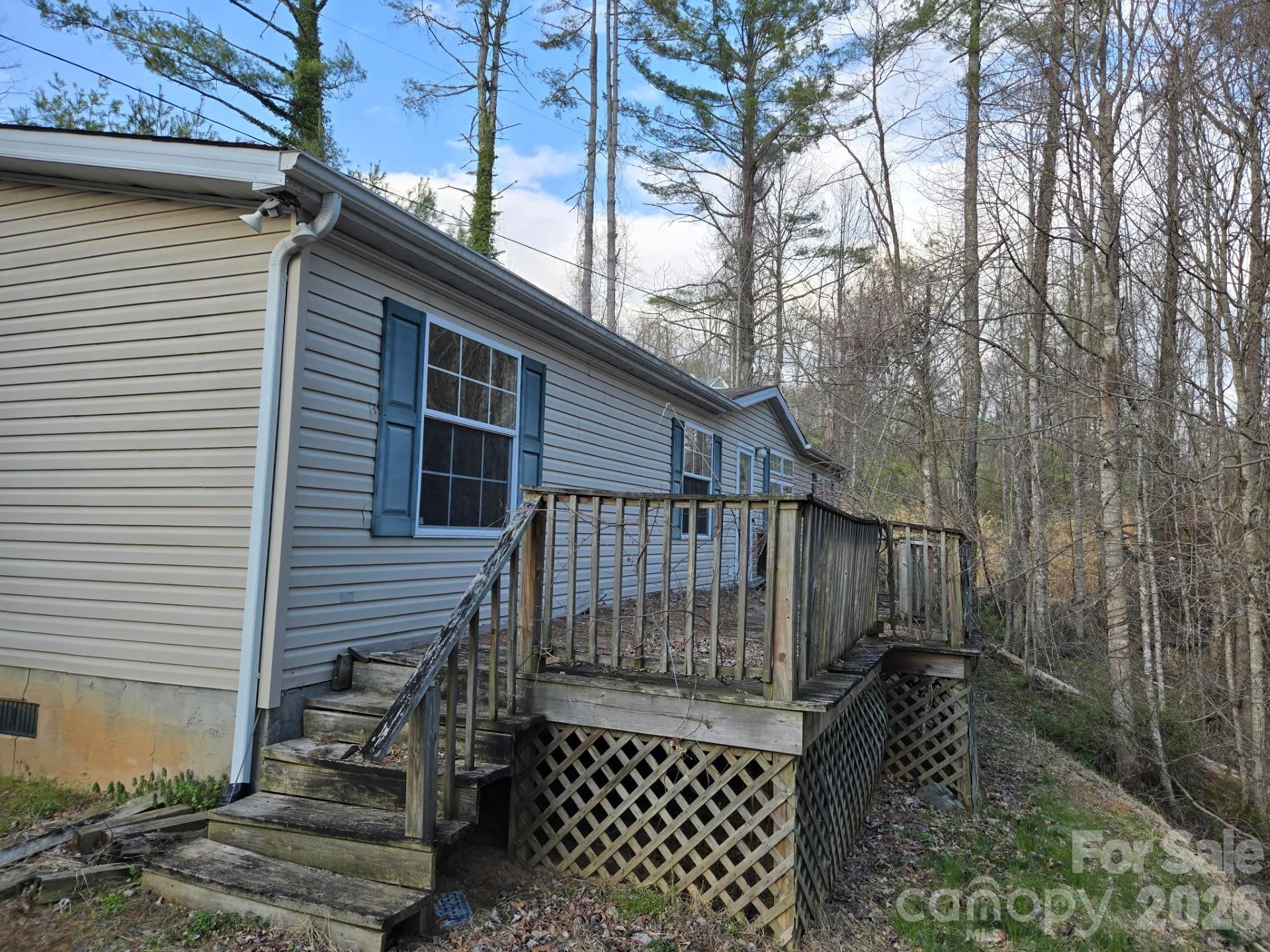 6 Woodland Street in Spruce Pine, NC is a 1618-square-foot ranch-style home on 1.56 wooded acres, offering true main-level living with an exterior ramp for easy access. Built in 1993, this property is a genuine fixer-upper and presents a prime investment opportunity for buyers ready to add value through updates and renovations. With its open-concept potential, single-level accessibility, and proximity to the Blue Ridge Mountains, the home is ideal for those seeking a customizable mountain retreat. The expansive lot provides privacy and room to create outdoor living spaces, while the home itself offers a solid foundation for personalization. Whether you’re looking for sweat equity, a value-add project, or a chance to craft a nature-inspired lifestyle, this property combines practicality with promise. Located just minutes from the charm of Spruce Pine, it’s a rare opportunity to transform a mountain home into your own vision.
