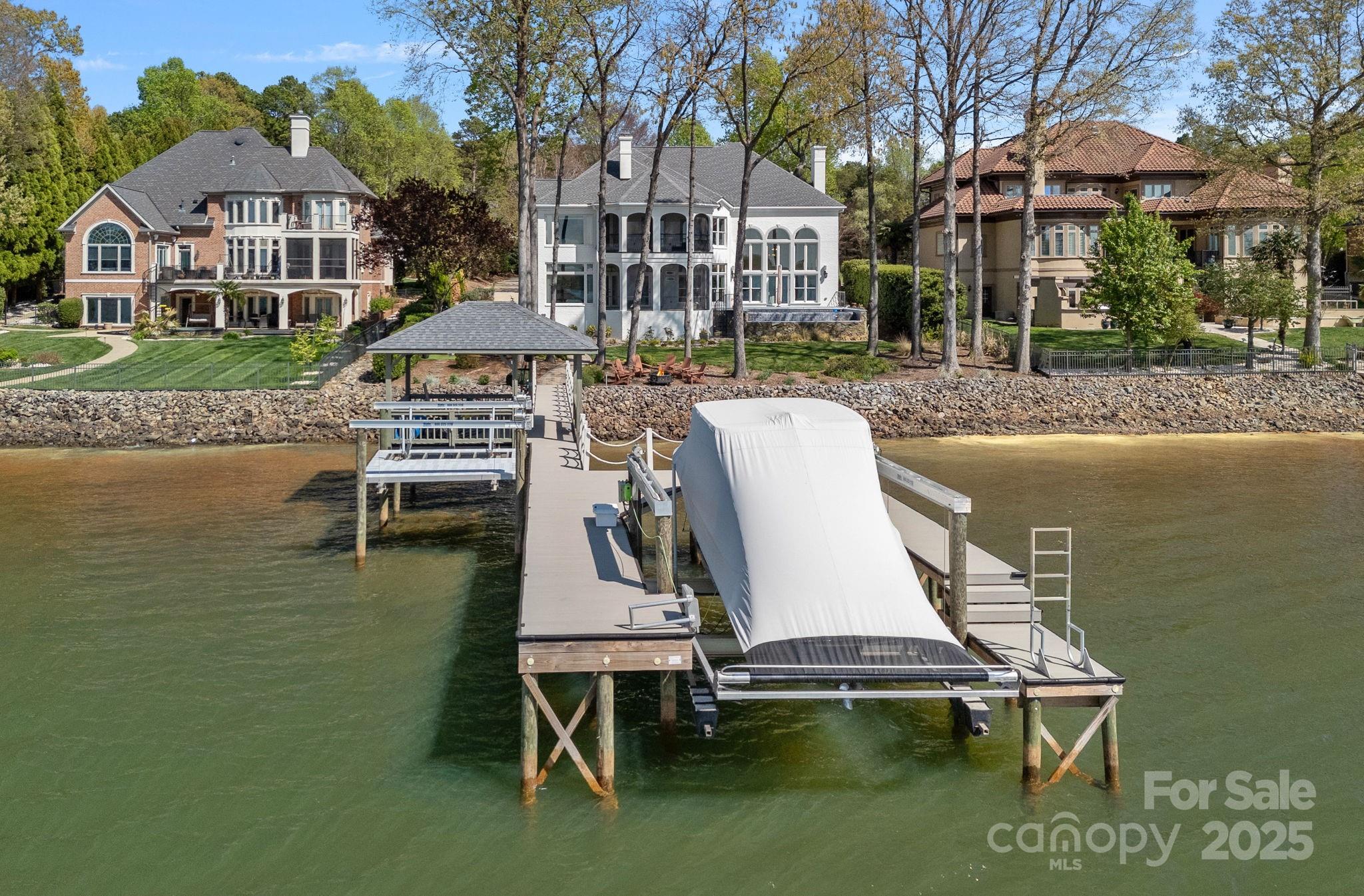Incredible views of SUNSET FOR MILES in the GATED WESTVIEW community off the Langtree Exit! GORGEOUS UPGRADES! Charming painted brick home with all systems updated. Move in and enjoy relaxation and entertainment in your new home! Beautiful hardwood floors lead to towering windows overlooking LAKE NORMAN in the grand 2 story living room! Full bath on main level provides a guest suite. The gourmet kitchen boasts Wolf appliances, quartz countertops, and opens to a screened patio. Three fireplaces enhance the ambiance throughout. Gracefully curved staircase guides you to a state-of-the-art theater room for more enjoyment, accompanied by an additional bonus space. The newly remodeled primary suite offers a sitting area and a screened porch. Upper level has three additional bedrooms, one ideal for an office with water views. Outdoor areas also feature surround sound and an infinity-edge saltwater spa/pool completing this idyllic retreat. Refer to  attached additions sheet for more details.