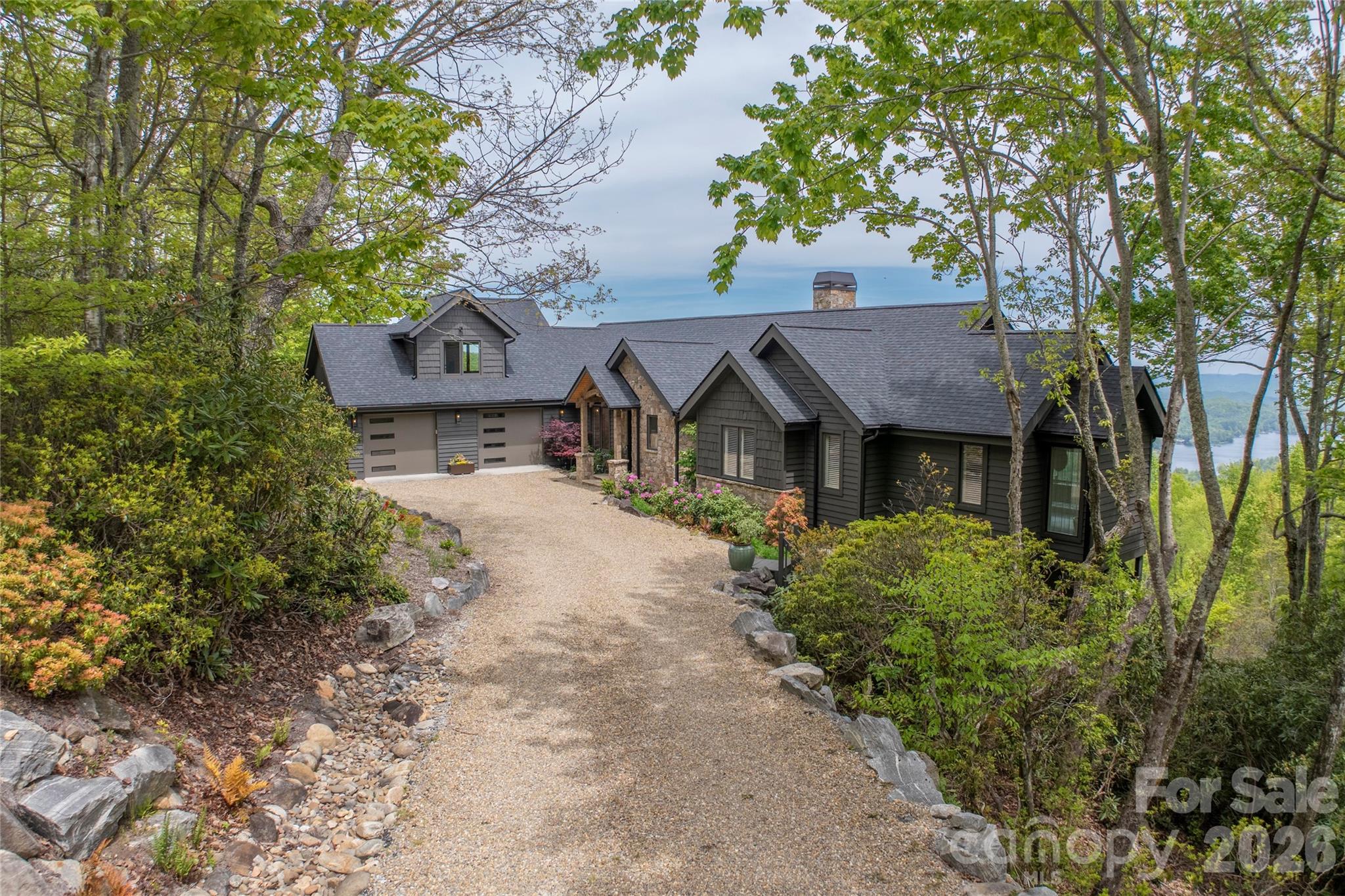 Perched within a quiet cul-de-sac in Lake Toxaway Estates, this beautifully renovated home captures the essence of refined luxury mountain living coupled with unparalleled mountain and lake views. A timber frame post-and-beam front porch with gas lantern, stone detailing, and Andersen French steel and glass entry doors creates a warm, elevated welcome. Having gone under an extensive transformation some exterior improvements include, new cedar shake siding and trim, a 30-year roof, new gutters, stone chimney, and a freshly painted exterior. Thoughtful updates are evident through the whole home.The primary bedroom features two renovated bathrooms and expansive closet space, with the laundry discreetly tucked within for added convenience. Notably the main level highlights a reimagined open floor concept with a fully equipped chef’s kitchen featuring a Sub-Zero refrigerator and a La Cornue range. The property has been extensively improved with a pea gravel and flagstone driveway, refined landscaping all designed to focus on the breathtaking long-range views. Also a refreshed guest apartment is located above the double bay enclosed garage. Truly a turnkey opportunity offering polished mountain luxury in one of Lake Toxaway’s most desirable settings. Membership to Lake Toxaway Country Club is based on application and availability.