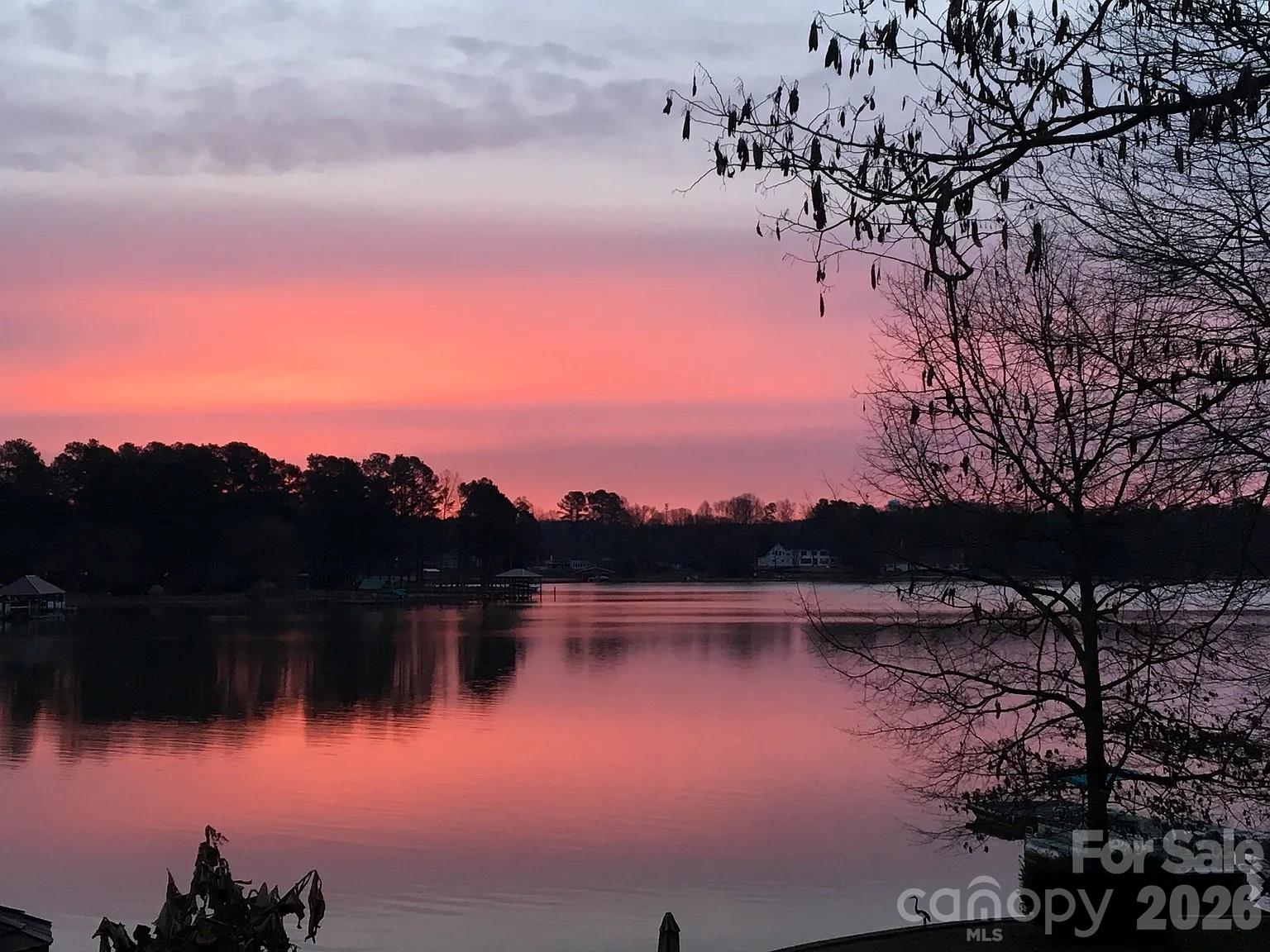 Rare Waterfront opportunity on Lake Norman with no HOA! Lakefront home situated on a peaceful 0.73-acre lot, 179 feet of shoreline, long-range water views, and gentle topography with easy access to the lake. Home offers single-level living with 2 bedrooms, 2 baths, plus a large third room currently used as a bedroom with lake views. Water views from primary, second bedrooms, and living area w/vaulted ceilings. The property features a private covered dock with a lift, an additional floating dock/lounge platform, and a sandy beach area. Ideal for boating, kayaking, swimming, and relaxing by the water. Outdoor living spaces include a large deck, a screened four-season porch, a raised tree deck overlooking the lake, a gazebo sitting area off the pier, a fire pit, and a beautifully landscaped yard with mature trees, flowering plants, and fruit trees. Additional features include an encapsulated crawl space, an insulated workshop under the deck, an irrigation system, a 10x12 shed, a 2-car carport, 3+ parking spaces, and a rocking chair front porch. This well-maintained property provides exceptional flexibility. Turnkey- ready to enjoy today, weekend retreat, perfect for a renovation project, or future new construction. Located in one of the most desirable and quiet areas of Lake Norman on the Brawley School Peninsula. Close to shopping and restaurants. Quick access to I-77, Davidson, and Charlotte, this is a rare chance to own waterfront property with unrestricted use. Must see- property offers outstanding potential in a prime Lake location—Pre-approval for viewing today.