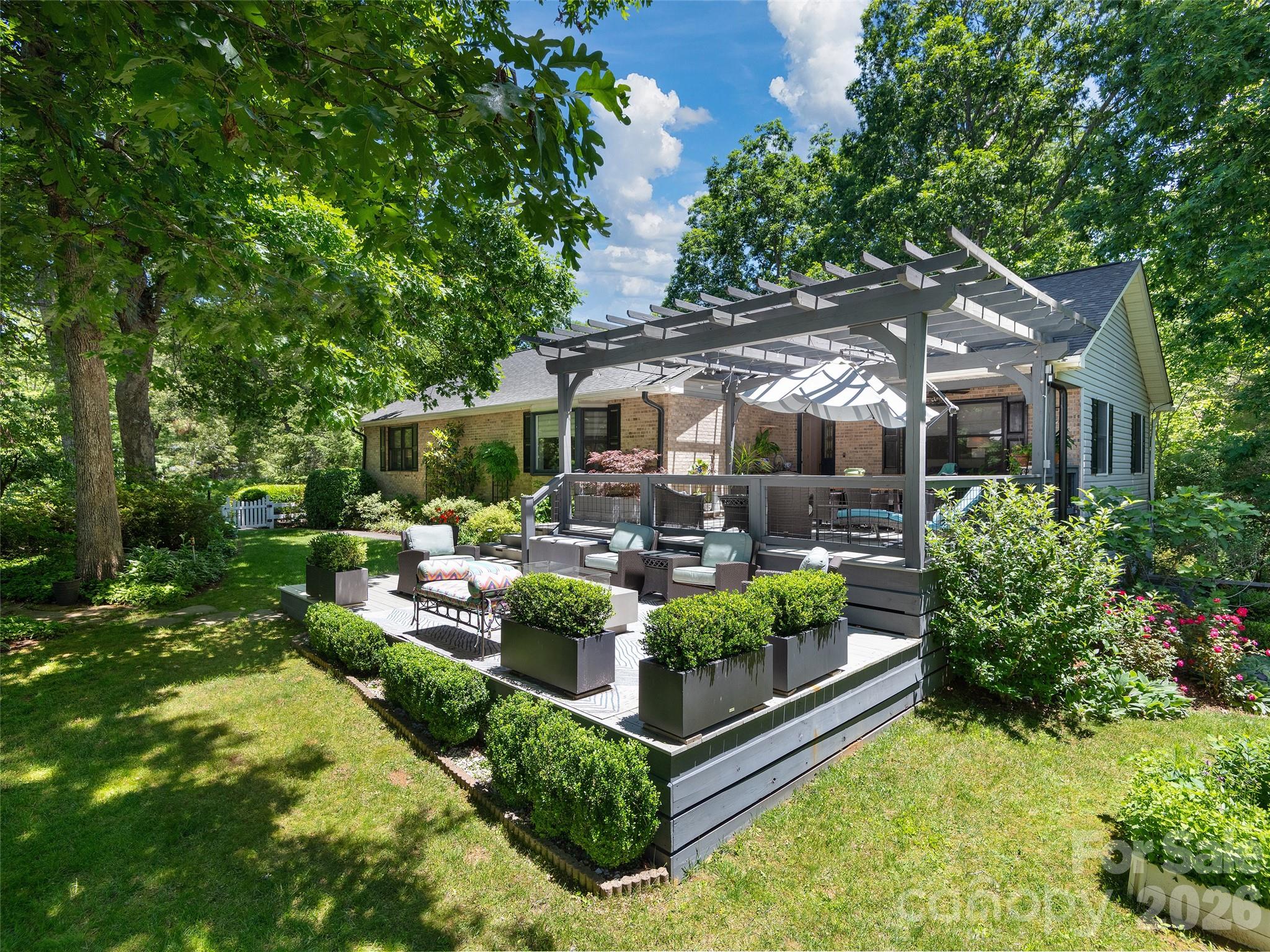 A rare blend of exceptional design, craftsmanship, and horticultural artistry, this remarkable Crooked Creek residence offers a lifestyle rarely found in today's market. Thoughtfully designed by a professional designer, both the home and its extraordinary gardens have been curated with an uncompromising attention to detail, creating a private retreat that feels more like a boutique estate than a traditional neighborhood home.
Set on beautifully landscaped grounds, the property unfolds through a series of breathtaking outdoor spaces featuring mature specimen plantings, vibrant seasonal blooms, manicured boxwood gardens, winding pathways, tranquil shade gardens, and intimate gathering areas designed to be enjoyed throughout the year. Every view has been carefully considered, transforming the landscape into a living work of art.
Inside, over 3,300 square feet of refined living space showcases high-end finishes, premium materials, and timeless design. The designer kitchen features exotic granite countertops, custom tilework, abundant cabinetry, and a spacious island that serves as the heart of the home. Elegant formal and casual living spaces flow seamlessly together, creating an ideal setting for both everyday living and sophisticated entertaining.
The luxurious primary suite serves as a private sanctuary with serene garden views, a custom walk-in closet, and a spa-inspired bath featuring a freestanding soaking tub, oversized walk-in shower, designer lighting, and carefully selected finishes. A spacious family room with exposed wood beams and a gas fireplace offers warmth, character, and exceptional flexibility.
Outdoor living rivals that of a private resort. Entertain beneath the custom pergola, gather around the firepit, dine al fresco in the covered outdoor living area, or relax on the expansive screened porch overlooking a peaceful wooded backdrop. Every outdoor space has been intentionally designed to create a seamless connection between home and nature.
Additional features include a three-car garage with workshop, abundant storage, a convenient dumbwaiter, private back staircase, and thoughtfully designed utility spaces that blend functionality with elegance.
Located within the sought-after Crooked Creek community, this is more than a home—it is a one-of-a-kind property where exceptional architecture, luxury finishes, and award-worthy gardens come together to create an unforgettable living experience.