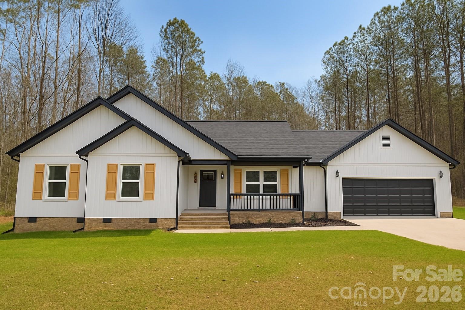 Welcome to this beautifully built new construction ranch home, offering thoughtful craftsmanship and timeless style on a peaceful 1-acre wooded lot in an established neighborhood with no HOA.

Step inside and you’ll immediately appreciate the open-concept design and natural light that fills the space. The spacious living area features vaulted ceilings and flows seamlessly into the modern kitchen, complete with soft close white shaker cabinets, quartz countertops, a large island, and stainless steel appliances.

The home includes 3 bedrooms and 2 full baths, offering comfortable one-level living. The primary suite provides a serene retreat with tray ceilings, generous windows overlooking the trees, a walk-in closet, and a beautifully tiled shower.

Outside, enjoy the quiet setting from your covered front porch or rear deck—perfect for relaxing or entertaining while surrounded by nature. The attached two-car garage provides convenience and extra storage space.

Located in North Lancaster, you’ll love the peaceful setting while still being conveniently located from shopping, dining, and schools—plus easy access to Indian Land, Rock Hill, and South Charlotte.