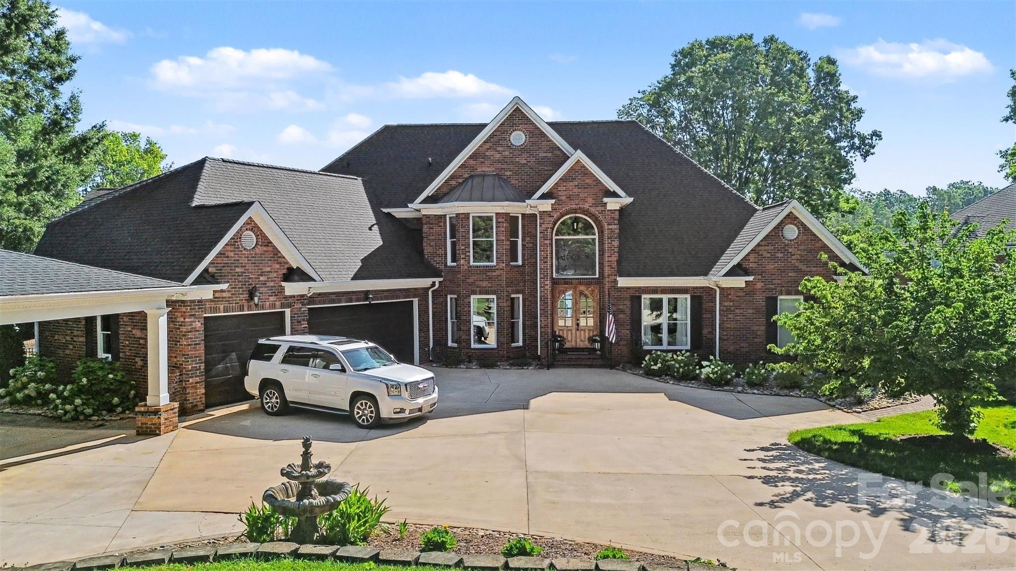 Picture yourself relaxing by your private swimming pool, sipping your favorite beverage while taking in sweeping waterfront views that stretch for miles. Now you can make this dream a reality. Experience refined lakefront living in this exceptional move-in ready full-brick estate, perfectly positioned to capture breathtaking water views on the shores of Lake Norman.  Designed for both elegance and comfort, this stunning residence seamlessly blends timeless architecture with thoughtful modern updates throughout.  Outdoor living takes center stage – relax beside the sparkling in-ground pool, entertain across multiple outdoor spaces, or step onto your covered private dock perfect for happy hour fun  and complete with boat lift for effortless days on the water.  Inside, the fully renovated chef’s kitchen impresses with quartz countertops, wall to ceiling kitchen cabinetry, and new state of the art Wolf and KitchenAid appliances – a sophisticated space equally suited for entertaining and everyday living.  The main-level primary suite offers a private retreat, highlighted by a striking see-through gas fireplace that creates ambiance between the bedroom and spa-inspired bath highlighted by basketweave tile flooring.  Hardwood floors extend throughout the main living areas, complemented by tile in all baths.  Upstairs, you will discover three generously sized secondary bedrooms, two full baths, a substantial size storage room, and spacious bonus room – ideal for recreation, media, or guest accommodations.  The third level features a finished flex space complete with a half bath, making it perfect for a home office, fitness studio, or additional guest quarters. Car enthusiasts will love the 3-car attached garage with professionally finished floor in addition to a 3-car attached carport. This is a rare opportunity to own a premier waterfront property offering privacy, luxury, and panoramic views in one of Lake Norman’s most desirable locations.