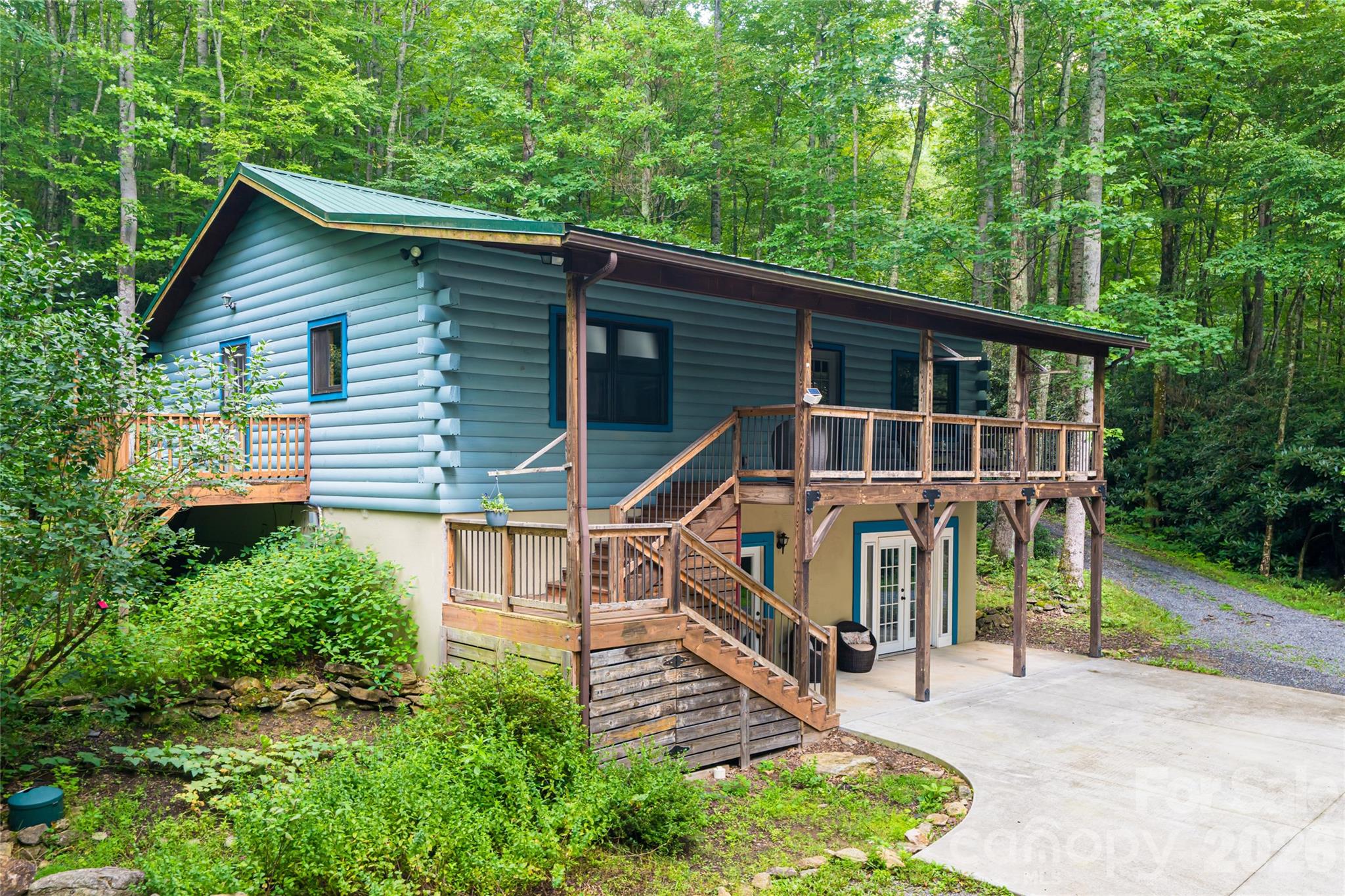 Tucked into the woods with a peaceful creek flowing through the property, this mountain retreat offers the perfect blend of privacy, comfort, and flexibility. Set on 1.86 acres, the home features 2 bedrooms, 2.5 baths, and over 2,200 square feet with a fully finished lower level ideal for guests, recreation, multigenerational living, or potential income-producing use. Warm wood finishes, vaulted ceilings, and expansive outdoor living spaces create an inviting mountain feel, while the covered porch, decks, patio, and fire pit area make it easy to enjoy the natural setting year-round. A fenced yard and additional fenced pet area offer space for animals, gardening, or everyday living. Custom chicken coop in place. The circular driveway provides easy access and ample parking. Located just a short drive to Waynesville and Asheville, this property works equally well as a full-time residence, mountain getaway, or investment opportunity with established long term rental potential.