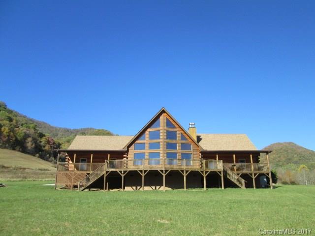 Stunning Log Home in scenic upper Crabtree area with year around mountain views and a stream.  Huge 2 story great room with floor to ceiling prow windows, split design covered rear porches w/ tranquil mountain views, Floor to ceiling stone fireplaces in great rm and master bedroom, 2 masters on main level, jet tub, kitchen has stainless steel appliances, granite, walk in pantry and granite window ledge. Upstairs has 2 BRs/1BA, loft area, storage closets and flex office room. 3 horses allowed.