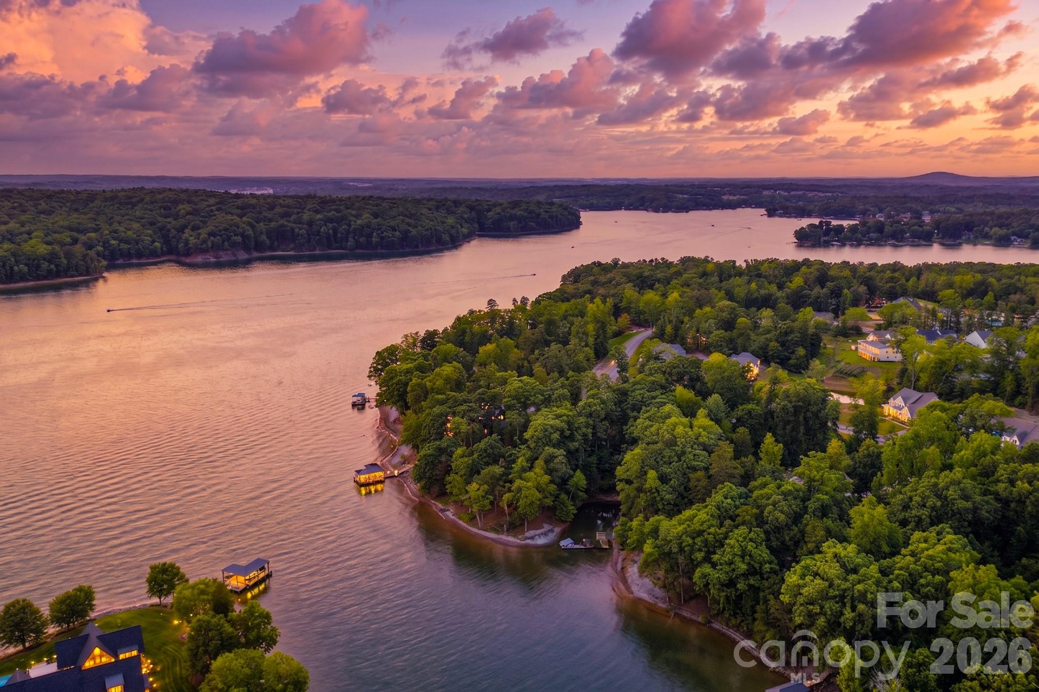 Your lakefront life starts on Homesite 336, with over 330 feet of shoreline. This level corner lot sits on a long peninsula along Lake Wylie in Belmont, NC, with a private sandy beach where you can walk right into the water on the cove side. With eastern exposure, you get morning sun and open lake views in every direction.

The lot gives you room to build the custom home you've been planning, with the option to add a basement on the left side. There's space for a dock to keep your water toys close and a pool when you want it. The land here has history too, once part of property owned by Daniel Stowe. Buy now and build on your own timeline. There's no deadline to break ground, and you'll work with one of McLean's approved builders when you're ready.

Beyond your own lot, McLean is built for life on the water. A full-service marina run by Morningstar Marinas sits at the community's southern edge with both wet and dry slips, so a boat is always close at hand. Right next to it is Drift, a waterfront restaurant known for fresh seafood, grilled steaks, and craft cocktails with the lake in view.
On land, residents have a clubhouse, outdoor pool, fitness center, and a growing network of walking and cycling trails. The Seven Oaks Preserve trail runs 2.8 miles along the shoreline through old oaks and tulip poplars, and it connects to Daniel Stowe Botanical Garden, one of America's "20 Great Gardens," where McLean residents get special membership rates. Evenings are easy here, whether that means a stroll at McLean Point waterfront park or sunset on the clubhouse deck.

Downtown Belmont, with its restaurants, shops, and year-round events, is about 10 minutes away, and grocery stores and more shopping sit within a 10-minute drive on either side of the bridge in Lake Wylie. Come take a look.