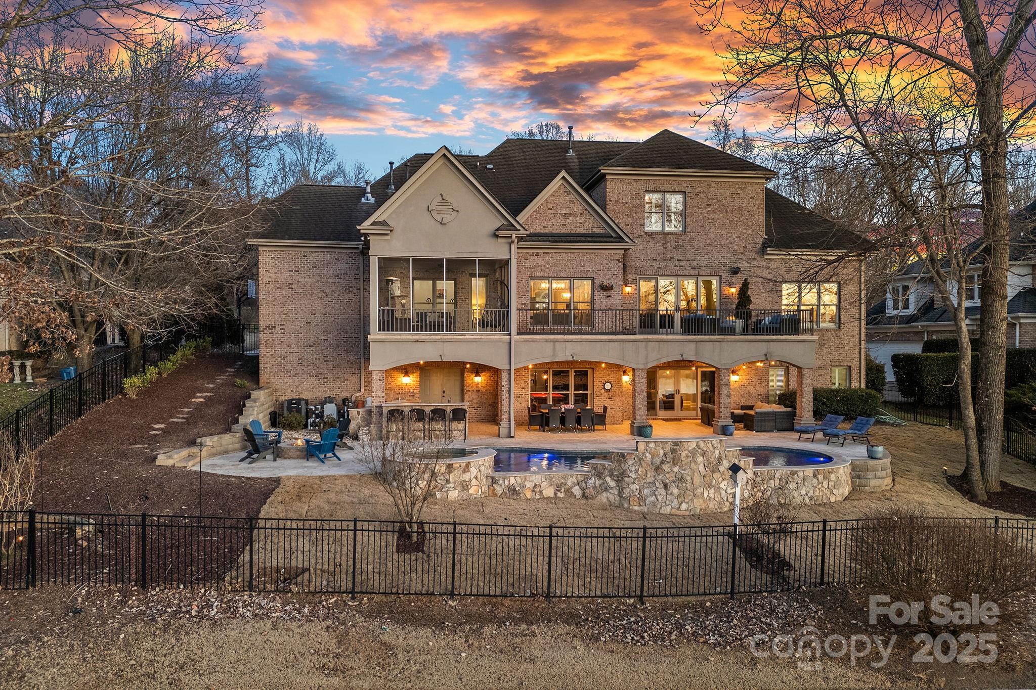 Experience luxury living in this stunning custom home on the 18th tee of River Run Country Club with breathtaking clubhouse and water views. The full brick exterior with stone accents complements the immaculate interior featuring an open floor plan with a vaulted, beamed keeping room and fireplace. The gourmet kitchen boasts custom cabinetry, granite counters, and SS appliances. Highlights include a coffered great room, formal dining with tray ceiling, and a vaulted study, all anchored by a dramatic two-story entry. The main-level primary suite is a spa-like retreat with an oversized tub and dual walk-in closets. Upstairs offers spacious bedrooms with en suite baths and 2nd office. The walk-out basement provides a private living space with a bedroom, bath, full kitchen, and entertainment areas. Outdoor living shines with a screened porch, expansive deck, heated pool, fenced yard, outdoor kitchen, 3-car garage,& 10’ ceilings. An unfinished space to create a theater, wine cellar, or more