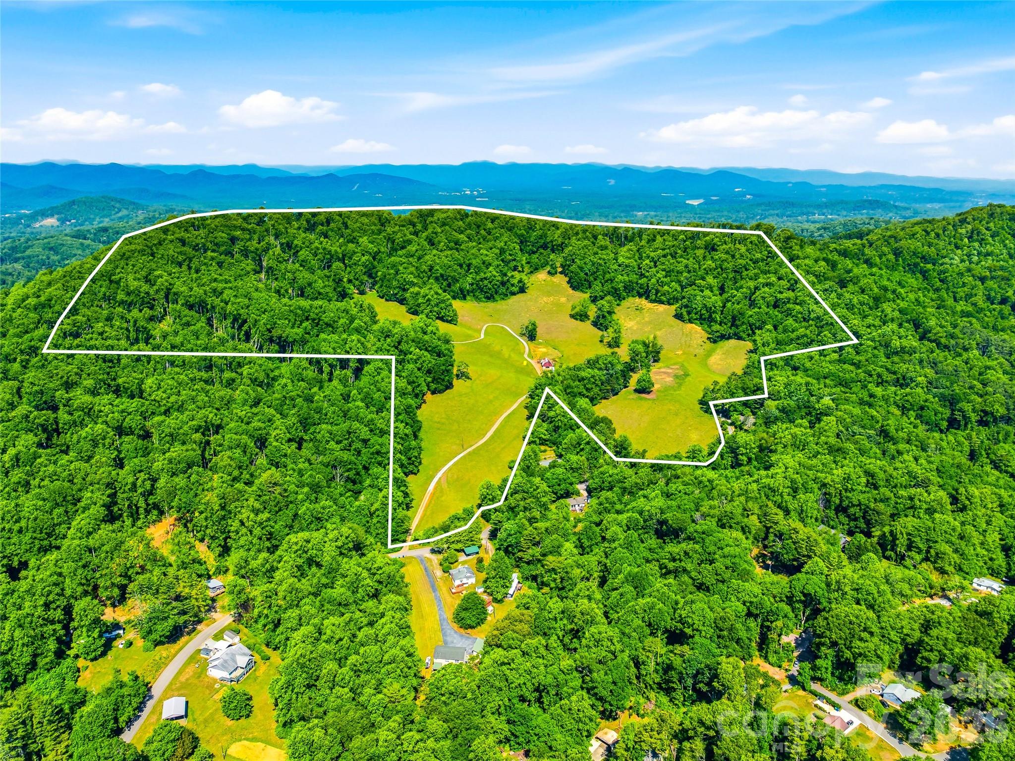 Set amid nearly 79 breathtaking acres in the heart of the Blue Ridge Mountains, this exceptional gated estate offers a rare combination of privacy, convenience to Asheville, natural beauty, and vintage Appalachian character. 

Expansive open pastures, gently rolling topography, and sweeping mountain vistas provide an idyllic setting for a family retreat, equestrian property, or private legacy estate. 

The property also includes an existing 3,600-square-foot authentic mid-century home built in 1978, featuring a stacked-stone chimney and two wood-burning fireplaces. The striking floor-to-ceiling chimney showcases stacked stone harvested from the property, creating a seamless connection between the home's interior and exterior. Whether enjoyed as a residence, guest house, caretaker's quarters, or future renovation project, the home provides an established presence on the property while allowing the land itself to remain the defining feature.

Complementing the home is a classic Appalachian barn, enhancing the property's rich mountain heritage and functionality.

Offering an exceptional balance of privacy and accessibility, the estate is located just 18 minutes from Asheville Regional Airport, 20 minutes to Downtown Asheville, and 3.5 miles from the Blue Ridge Parkway. Large contiguous tracts with this combination of usable pastureland, mountain views, and proximity to Asheville are increasingly rare, making a property of this scale, beauty, and accessibility a truly exceptional opportunity to create a lasting mountain legacy.