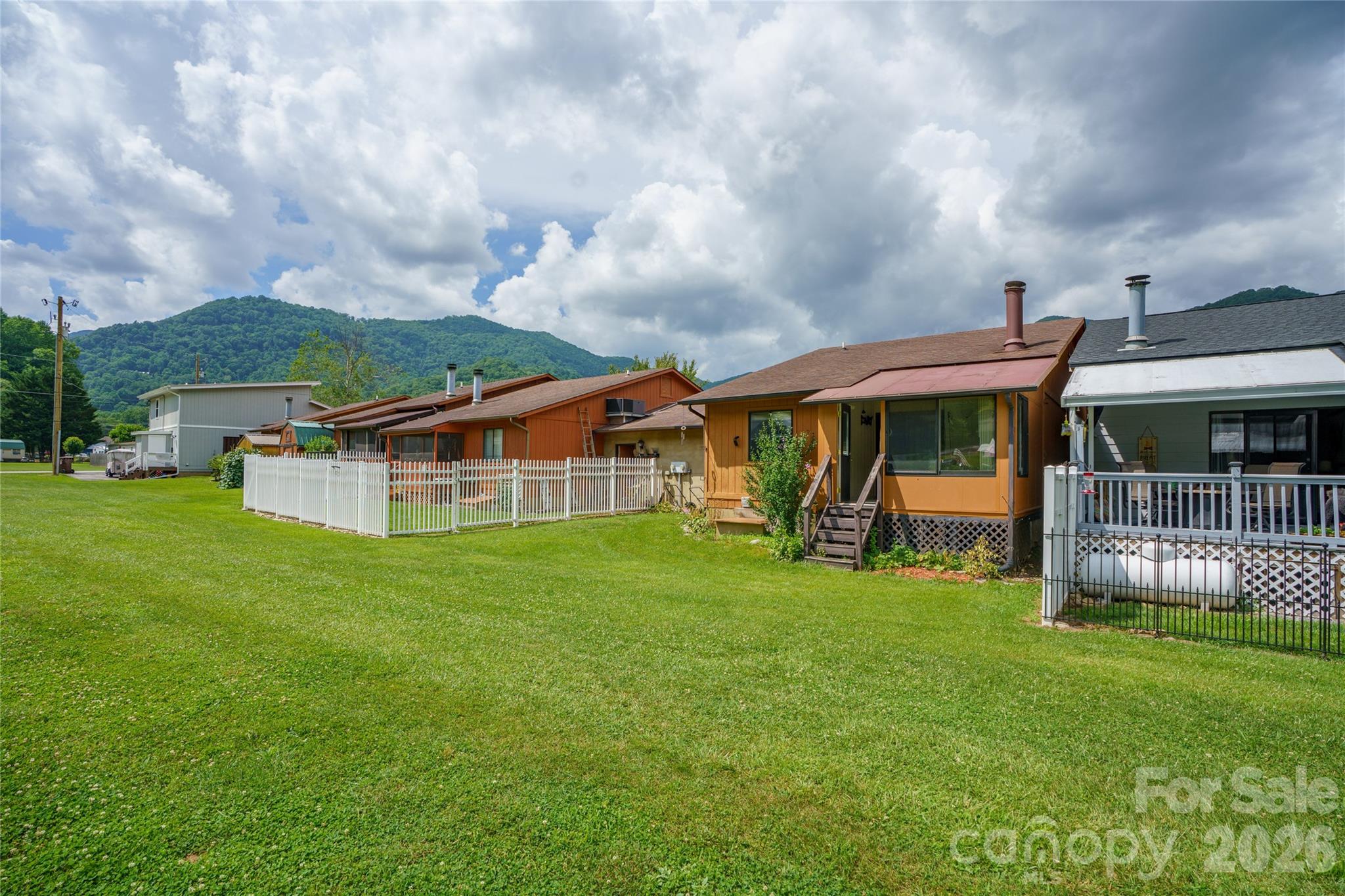 ROOF 2025 • ONE-LEVEL LIVING with GARAGE • LONG-RANGE MOUNTAIN VIEWS • Very Desirable location • WALKABLE MAGGIE VALLEY

Enjoy mountain living with rental investment potential in this updated 2BR/2BA one-level home with 1 step to the GARAGE in the heart of Maggie Valley. Fresh paint, roof 2025, smooth 9-ft ceilings (no popcorn!), heated sunroom, gas fireplace, flat paved access and parking, city utilities and low-maintenance living ,No HOA fees— perfect for short or long term rentals, retirees, second-home owners, or any buyer seeking comfort without hassle.

Easy access. Lock-and-leave convenience. Rare heated sunroom with southern exposure and long-range views. Elk frequent the yard. Walk to restaurants, shops, and Festival Grounds on Maggie's popular sidewalks.

Recent updates include a NEW ROOF, fresh interior paint, and smooth 9-foot ceilings (no popcorn) throughout the home. All living spaces are conveniently on one level, including the living room, kitchen, sunroom, 2 bedrooms, 2 full baths, front porch and laundry room —no interior stairs to manage. Just one step to the garage, making it easy with groceries or with inclement weather.

Additional highlights include:
... True one-level living

... Flat, paved year-round access

... Heat pump for heating and AC ... Primary bedroom with ensuite bathroom 

... City water & city sewer. No HOA fees.

... Attached garage (home connected to the neighbor at garage only for added privacy)

... Covered front porch

... Low exterior yard maintenance

... Schedule your showing today. This home is designed for comfort and simplicity.

The home offers a heated sunroom which faces beautiful mountain views and enjoys southern exposure for natural light all day long. The primary bedroom includes an ensuite bathroom and overlooks the backyard with views of both the garden and the mountains.... All living areas are on one level—including the living room, two bedrooms, two full bathrooms, a sunroom, laundry room, and attached one-car garage. The kitchen features stainless steel appliances, a breakfast bar, and a country-style layout that opens to both the living area and the sunroom and where a gas fireplace adds warmth and charm, perfect for cool mountain evenings. The  heated sunroom is a fabulous addition that most homes do not have.

The backyard is small and easy to manage—ideal for someone who wants a touch of outdoor space without hours of lawn care. The elk visit this yard frequently. There’s room for a pet, small garden, or fire pit. The front covered porch offers another spot to relax and enjoy the mountain air.

Flat, paved access makes this home easy to reach in all seasons, with a heat pump for AC and heat, city water and city sewer for added convenience. The home is attached at the garage only, providing privacy while reducing exterior maintenance responsibilities. 

Location is a key advantage: walk to the Maggie Valley Festival Grounds, restaurants, and local shops. A short drive takes you to Waynesville’s historic downtown, the Blue Ridge Parkway, Cherokee Casino, or Asheville’s airport and cultural attractions.

If you’ve been looking for a clean, comfortable mountain home that doesn’t come with a big yard or steep roads, this property checks all the boxes. Easy to live in, easy to lock and leave, and easy to enjoy—schedule your showing today.

One-level homes with views, city utilities, and walkable locations are increasingly rare in Maggie Valley.
