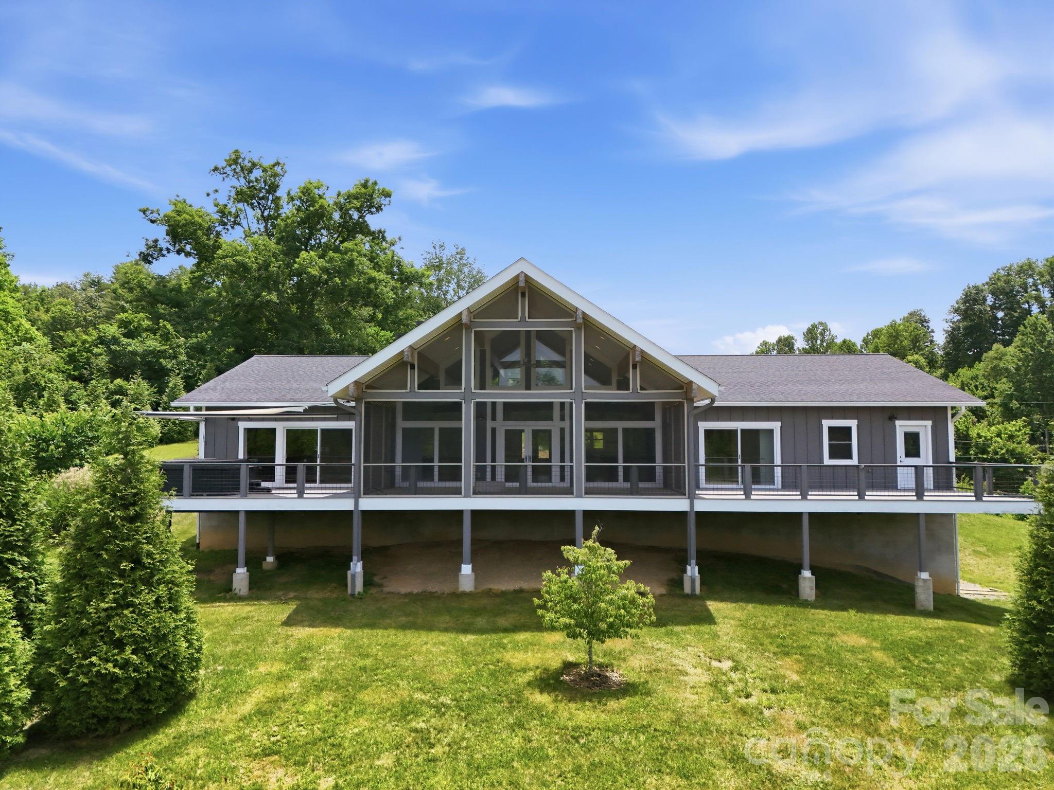 Set on 6.22 private acres with sweeping long-range mountain views, this custom-built Weaverville estate offers the rare combination of luxury living, exceptional utility, and room to grow. In addition to the beautifully designed main residence, the property features a substantial detached garage/workshop complete with a full bathroom and dedicated office space already in place, offering incredible flexibility for remote work, creative pursuits, business operations, hobbyists, collectors, or future customization. The main home also includes a 1,429 sq ft attached garage, providing abundant room for vehicles, equipment, storage, and recreational gear.

The thoughtfully designed main residence features approximately 2,950 heated square feet of primarily single-level living highlighted by soaring vaulted ceilings, exposed wood beams, expansive windows, and an open-concept layout that seamlessly connects the living room, dining area, and chef's kitchen.

The spacious great room is anchored by a fireplace and framed by panoramic mountain vistas, while the gourmet kitchen features premium appliances, custom cabinetry, and an oversized island designed for entertaining. The primary suite serves as a true retreat with its own fireplace, spa-inspired bath, freestanding soaking tub, walk-in shower, and generous closet space. Two additional bedrooms and full baths provide comfortable accommodations for guests.

Outdoor living is equally impressive with a large screened porch, expansive decking, hot tub, fire pit, and multiple spaces designed to take full advantage of the surrounding mountain scenery. The property also features an established orchard, creating a picturesque setting and offering additional appeal for those seeking a more self-sufficient mountain lifestyle.

Beneath the home, an approximately 2,116 sq ft unfinished basement presents exceptional value-add potential for additional living space, recreation areas, storage, workshop use, or future expansion. Combined with the detached garage/workshop, office space, full bath, and attached garage, the property offers a rare blend of luxury, flexibility, and opportunity that is increasingly difficult to find.

Beautifully maintained grounds, privacy, year-round mountain views, and multiple opportunities for customization complete this exceptional offering just minutes from downtown Weaverville and a short drive to Asheville.

A rare opportunity to own a luxury mountain estate with outstanding utility, expansion potential, and the space to create a truly one-of-a-kind property.