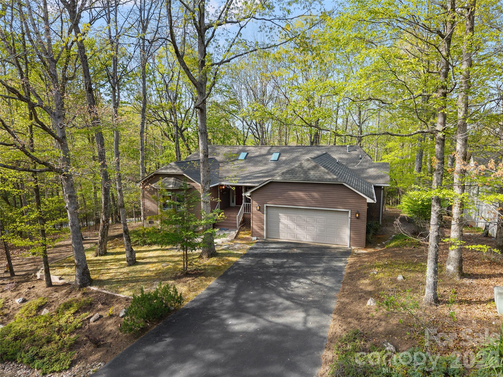 Discover the perfect mountain retreat in this spacious 3-bedroom, 2-bathroom home featuring 2,226 square feet of heated living space on one level. The interior is bathed in natural light from four skylights and features a master suite with a walk-in closet. Updates throughout include a mix of hardwood, ceramic tile, laminate, and carpeted floors.

The heart of the home is the expansive heated sunroom, providing a year-round vantage point to watch local wildlife. For outdoor enjoyment, step onto the open grilling deck or the covered front porch. The exterior is designed for low maintenance with vinyl siding and aluminum trim. This property is a rare find in Connestee Falls, offering a flat, usable yard and a dedicated dog enclosure for pets.

Practicality meets potential in the massive unfinished basement, which is perfectly suited for a dream workshop or fitness studio. Significant recent upgrades include a new Goodman heat pump system installed in 2024 for efficient climate control. A spacious two-car garage provides ample parking and additional utility space.
Perfectly positioned for an active lifestyle, this home is moments away from the golf course, the clubhouse, and the fishing and swimming waters of Lake Tiaroga and Lake Ticoa.