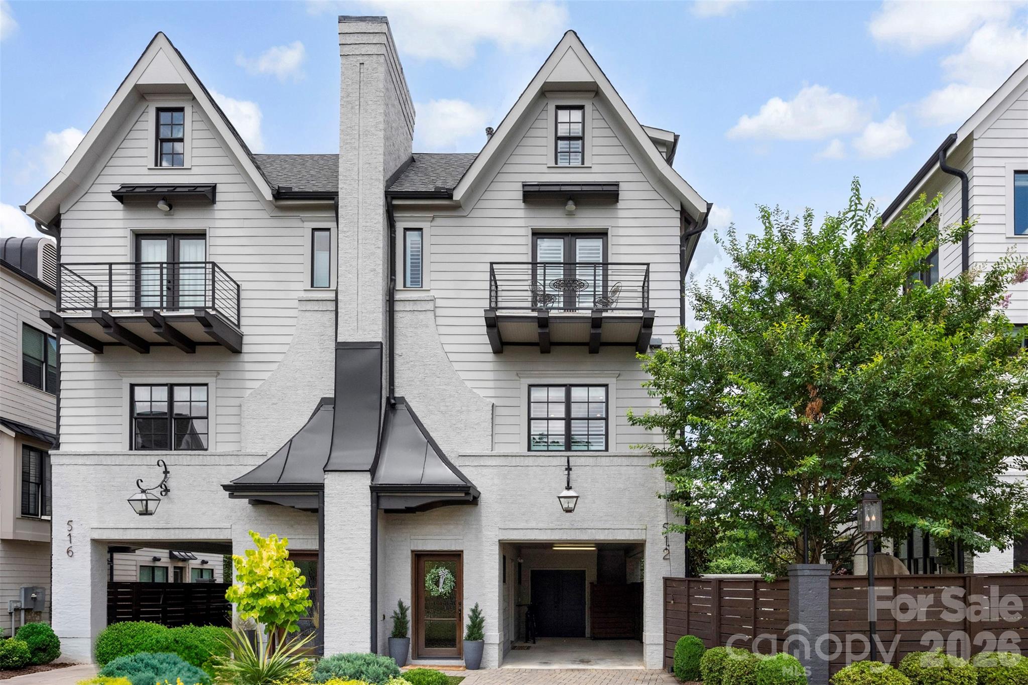 Welcome home to a blend of timeless architecture, thoughtful design, and modern luxury in the heart of Elizabeth. This fully custom townhome showcases designer finishes and exceptional craftsmanship throughout, creating an effortlessly livable experience. Highlights include a chef's kitchen featuring Thermador appliances, a custom range hood, oversized island, and a fully integrated Control4 smart home system easily managed from your mobile device. Every level showcases elevated finishes including wide-plank hardwood floors, custom lighting, intricate millwork, built-in features, and distinctive architectural accents. The luxurious primary suite offers a spa-inspired bathroom and custom walk-in closet, while the lower-level flex space with a dry bar provides endless possibilities for entertaining, working, or relaxing. Enjoy three private outdoor spaces, including a covered balcony off the main living area, a private balcony for the secondary suite, and a fenced backyard with a paver patio, built-in gas fireplace, and turf. This low-maintenance home offers a true lock-and-leave lifestyle without compromising quality, comfort, or design. Located just a stone's throw from Uptown, Independence Park, Memorial Stadium, Little Sugar Creek Greenway, Plaza Midwood, Midtown, and endless dining, shopping, and entertainment options. This rare opportunity combines luxury, location, community, and lifestyle. 512 Living Way is more than a home, it is the elevated urban living experience you’ve been searching for.