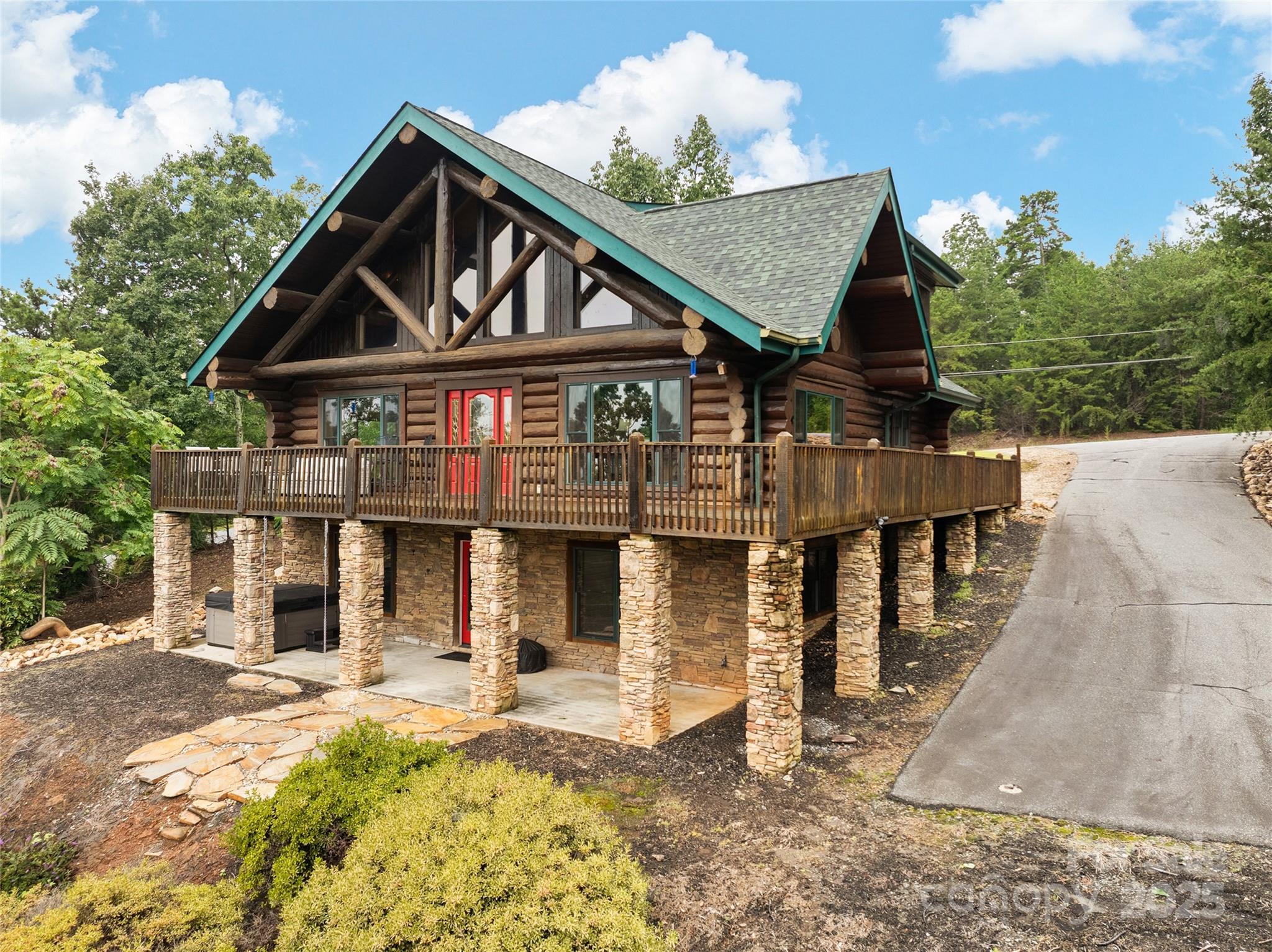 Tucked into the Blue Ridge, this exceptional three-bedroom, two-bath log home is a private mountain retreat where rustic character meets modern comfort. Set on 5.33 wooded acres within a gated community, it is surrounded by towering trees, fresh mountain air and long-range views that shift with the seasons. A classic log façade and expansive front deck invite a slower pace, while misty mornings, vibrant autumn color and glowing sunsets provide a breathtaking daily backdrop. A nearby waterfall adds the soothing soundtrack of nature. Inside, an open floor plan is anchored by a dramatic rock fireplace beneath vaulted ceilings and walls of windows that flood the space with light. Rich hardwood floors and log walls balance rugged elegance with refined living. The main-level primary suite allows one-level living, while upstairs bedrooms offer flexible space for guests or work-from-home needs. Thoughtful updates include a new roof, new upstairs heating and air, new floors, new windows and freshly stained exterior. Sold fully furnished and move-in ready, with an unfinished, climate-controlled basement offering future potential, this home delivers timeless log-home living immersed in beauty, privacy and serenity.