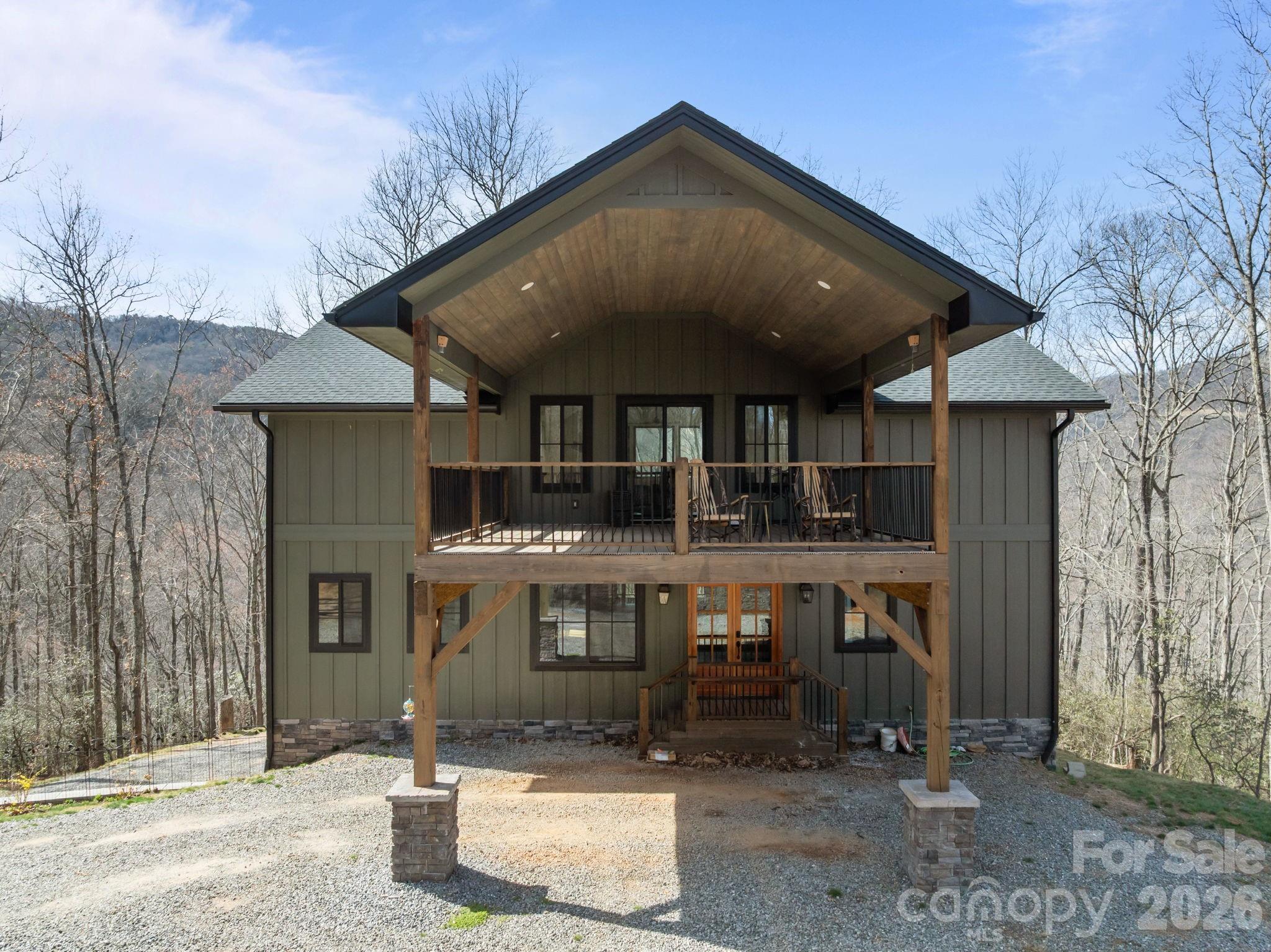 Tucked away at the end of a long winding private drive, this mountain retreat offers the rare combination of modern construction, expansive acreage, and peaceful seclusion on approximately 20 acres in Candler. Surrounded by natural beauty and elevated views, 215 Ridgeway Road is designed for those seeking privacy, space, and connection to the outdoors.
The home welcomes you with a striking exterior, covered entry, and generous outdoor living spaces that immediately invite you to slow down and take in the mountain setting. Expansive covered decks create an ideal place for morning coffee, evening gatherings, or simply enjoying the quiet surroundings and seasonal views.
Inside, the open-concept main living area is filled with natural light and features soaring ceilings, oversized windows, and large sliding doors that seamlessly connect indoor and outdoor living. The spacious kitchen is the centerpiece of the home, complete with a large island, abundant cabinetry, and an easy flow into the living and dining spaces—ideal for entertaining or everyday comfort.
The dramatic great room offers impressive volume and warmth, with tall ceilings and oversized glass framing the surrounding landscape. Large windows throughout the home bring in light while emphasizing the peaceful wooded setting.
The unfinished basement provides significant opportunity for expansion, storage, workshop space, recreation, or future customization to fit your needs. Whether envisioning additional living quarters, hobby space, or guest accommodations, the lower level adds valuable flexibility.
With acreage that offers room to explore, garden, create trails, or simply enjoy privacy, this property presents a unique mountain lifestyle opportunity just a short drive to local conveniences, dining, and access to Asheville.