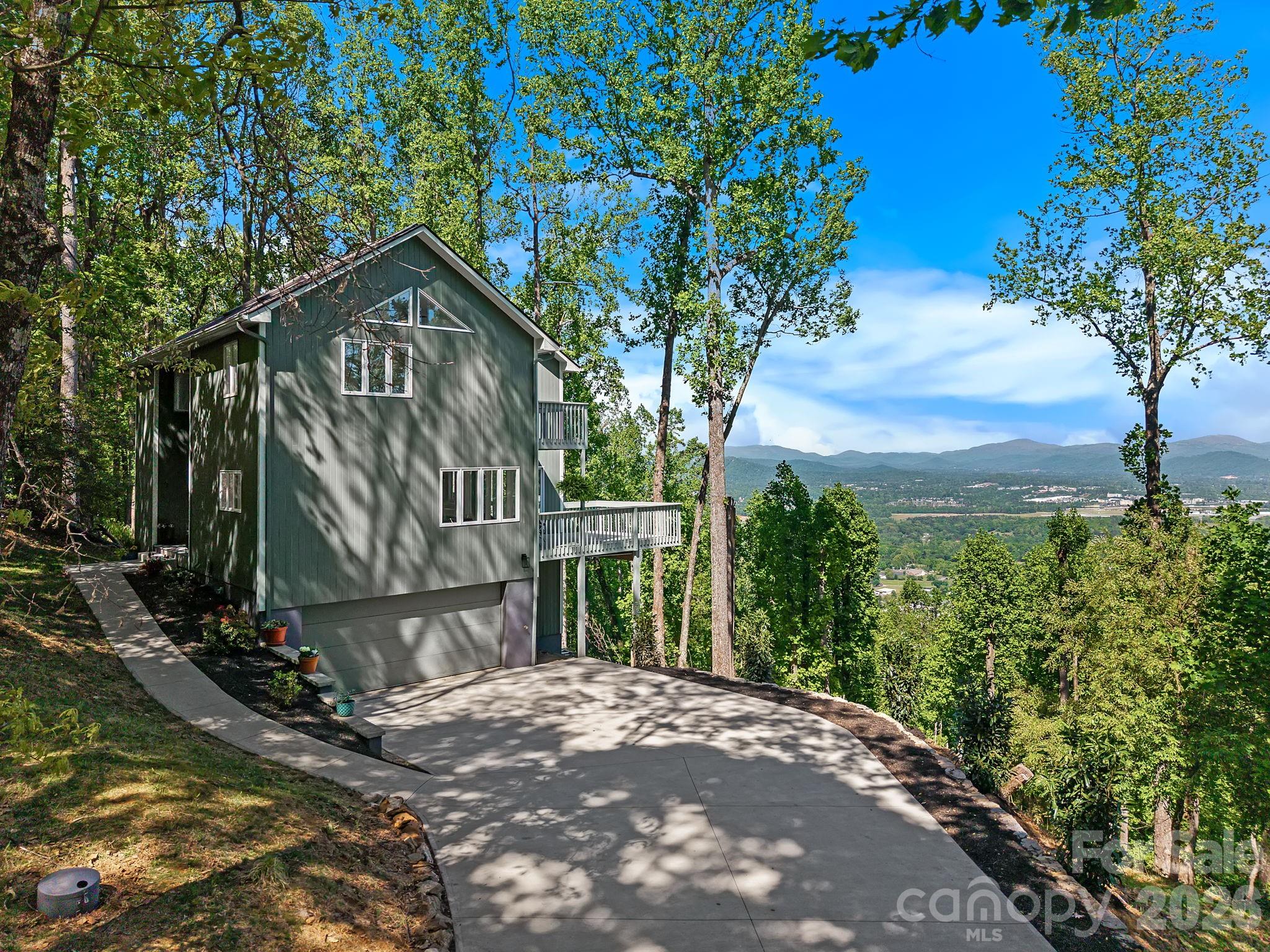 Commanding a rare vantage point at 3,000 ft within the prestigious High Vista Golf community, this architecturally striking home captures panoramic mountain views that feel truly boundless. Each morning offers a truly magical experience, as breathtaking sunrises unfold and fog gently melts off the French Broad River below. From the moment you open the front door, the mountain view overwhelms the senses, framed by a dramatic wall of glass that draws the scenery into the living spaces. A soaring 22’ ceiling defines the great room, enhancing both scale and presence. Rich 5” solid maple floors, Craftsman trim, and a cozy fireplace add warmth and depth. The primary suite offers a private deck, a custom closet, and a spa-like en suite bath with heated marble floors, a soaking tub, and a custom marble shower. Two additional bedrooms and a full bath provide flexibility. A flat driveway, dual offices, gym/flex space, and a well-appointed kitchen complete the home. High Vista offers a vibrant lifestyle with golf, tennis, a clubhouse, pool, and social events. Well-positioned between Asheville and Hendersonville, with easy access to the Blue Ridge Parkway and the airport.