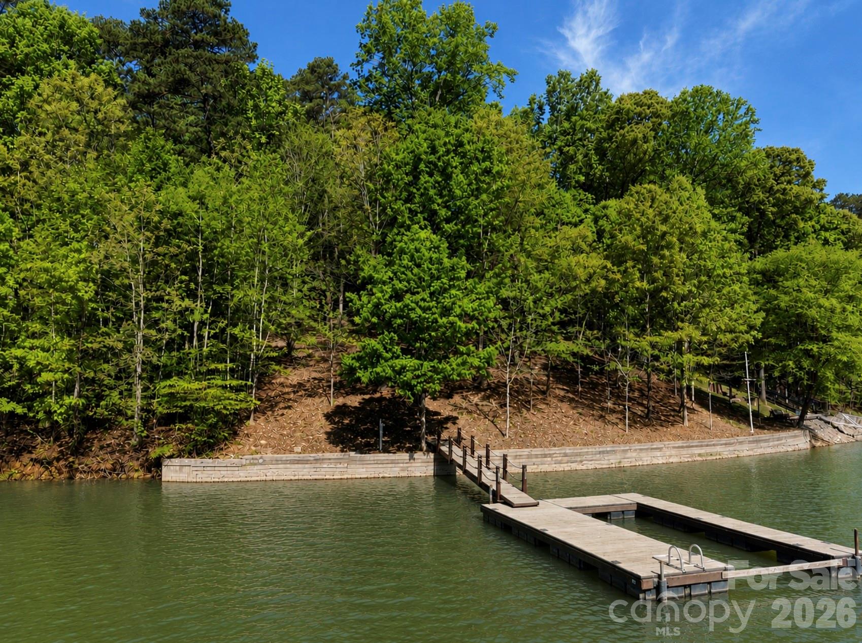 Rare opportunity to build your dream waterfront home in Harbour Watch, a private gated community known for its oversized lots, privacy, and peaceful setting. This .64-acre lot offers approximately 150 feet of shoreline on a wide, deep-water cove just off the main channel of Lake Norman—no dredging needed. A dock with Trex decking is already installed, a major value-add with current construction costs for similar docks starting around $60,000 in today’s market. A block seawall is also already in place, with comparable seawall installations currently ranging from $60,000–$80,000+, providing long-term shoreline protection and peace of mind.

The property is beautifully wooded with mature hardwoods and has been cleared of undergrowth, making it easy to walk, explore, and envision your future home site. A permanent 4-bedroom septic permit is already on file and will never require renewal. While Lake Norman is known for busy roads and waterways, this location offers a rare escape from traffic both on and off the water, delivering the quiet, relaxed lake lifestyle buyers are searching for. A truly exceptional homesite in one of Lake Norman’s most sought-after gated communities. (Photos were taken when Lake Norman was 4.4 feet below full pond. At normal levels water touches seawall)