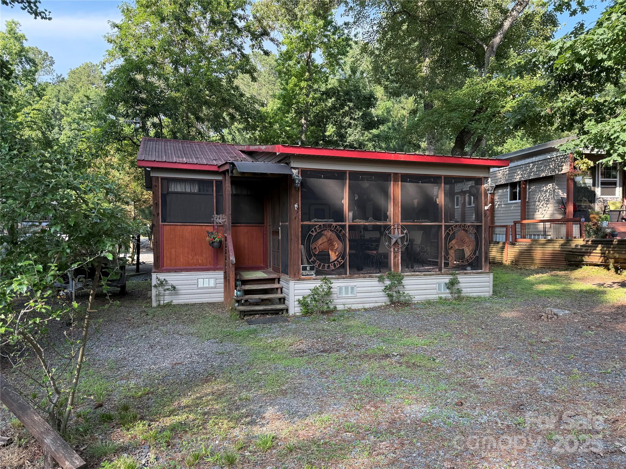 Welcome to a fabulous deck with great shade trees. Double lots for plenty of parking for all your lake toys. This well maintain 1995 30' Dutchmen is ready for you to come enjoy. Front end kitchen always give additional space, wall mounted propane heater, newer flooring and refrigerator inside. Big refrigerator on Porch. Nice sitting area, bar area and dining area all on this oversized covered front porch. Owner has installed a cut off switch for the 12v lights. real potty, small outbuilding with enclosed lean to. Most furnishings to remain. All clients must be with a realtor to gain access to the community.