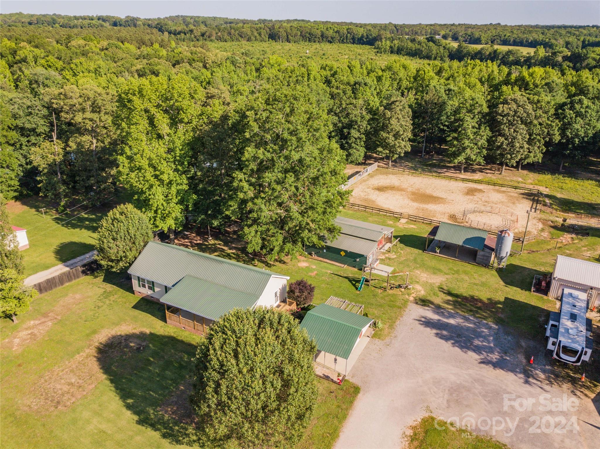 Horse Lovers Dream!!!! This beautiful, well maintained property, located in the desirable Buford community, has everything you need to make you and your horses feel right at home from the moment you arrive. This home greets you with an inviting, covered front porch allowing you to enjoy the beautiful South Carolina weather. This home has 3 bedrooms and 2 baths with an open floorplan. The kitchen has an island and a walk-in pantry. The primary bedroom has a large walk-in closet and ensuite with separate shower and garden tub, double sinks and lots of storage.  There is an entryway into the laundry/mudroom from the side porch that connects to the front porch and runs the width of the home. There is a two car, 24X24 metal carport, along with two barns that have electricity, a covered picnic area with bathrooms and electricity overlooking a fenced area for horses with a pasture in the back.