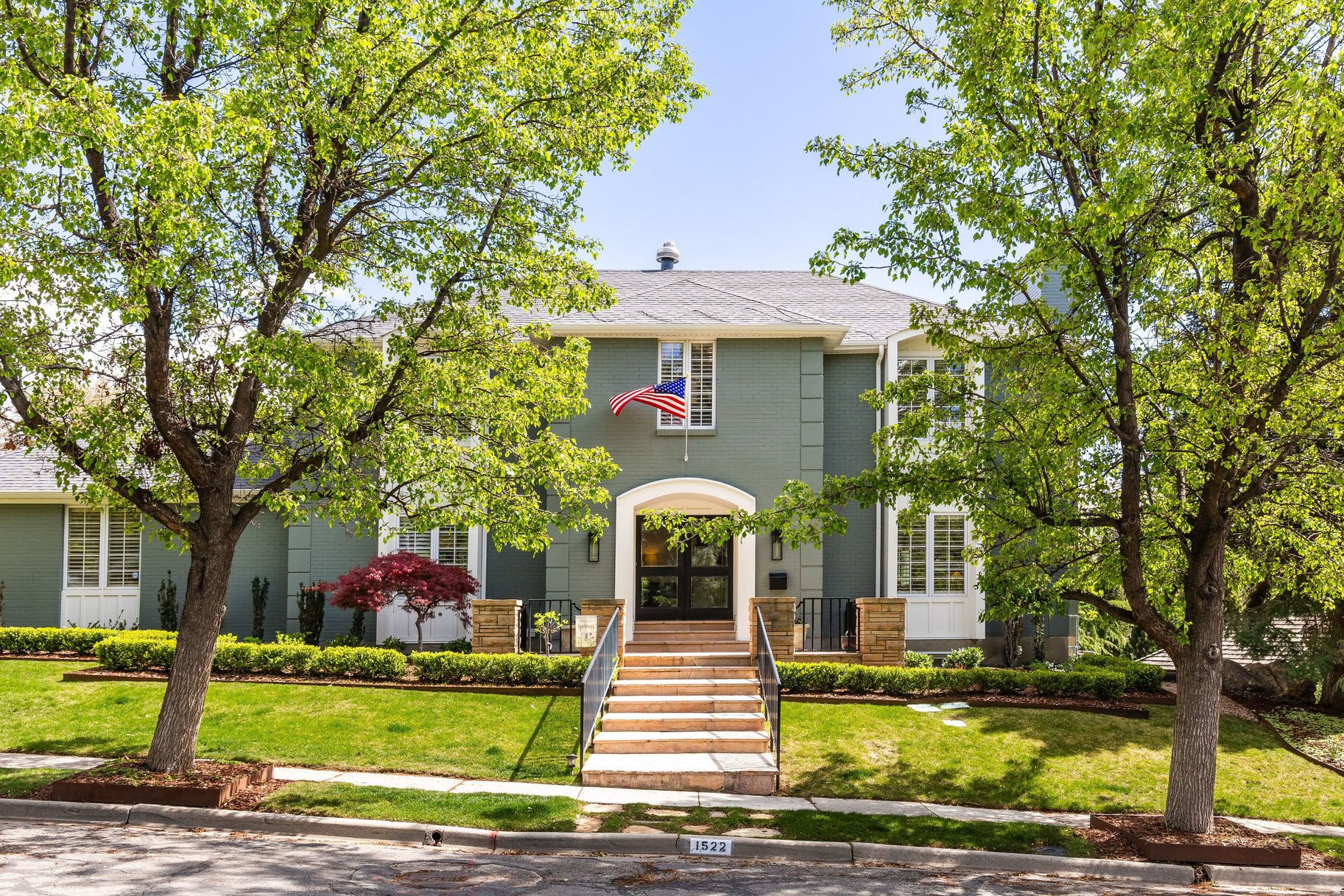 Stately two-story home located in Federal Heights, one of Salt Lake's most prestigious neighborhoods. An impressive entry welcomes you with glass front doors and a beautifully redesigned staircase. Recently remodeled in 2024, this home is in meticulous condition and showcases high-end finishes throughout. The spacious living room flows seamlessly into the well-appointed kitchen and main floor family room, with a formal dining room completing the exceptional floor plan. The living room mantle was professionally designed and custom-built for the home, perfectly complementing its style. The redesigned kitchen is a true showpiece, featuring a new island with a stunning Madeirus quartzite waterfall countertop, quartz surfaces, a new sink and fixtures, and a stylish tile backsplash. Top-of-the-line appliances include a 48-inch Sub-Zero refrigerator/freezer, 48-inch Wolf range, Cove dishwasher, Sub-Zero wine refrigerator, and Sub-Zero beverage refrigerator. The mudroom has been thoughtfully updated with new cabinetry and a built-in bench. The kitchen's dining area flows seamlessly into the main-level family room, highlighted by stone floors and a dramatic fireplace. A bonus playroom with custom built-ins completes the main floor. Hardwood floors have been refinished on the main level, with new hardwood installed on the staircase and throughout the upper level, except in the tiled bathrooms. Upstairs, the primary suite offers dual closets and a spacious bathroom with double vanities, a separate tub and shower, heated floors, and a private office with its own fireplace. A bright and airy workout room adjoins the primary bedroom. Two additional bedrooms include one en-suite, plus a third bedroom with a separate bathroom. The upstairs office can easily be converted to a 4th bedroom. The lower level features above-grade windows, new carpet, a large family/playroom, a laundry room with new tile and cabinetry, a guest bedroom, and a newly remodeled bathroom. The front and backyard have been completely reimagined with new professional landscaping, garden beds, sprinklers, and fencing.  An attached two car garage adds the finishing touch to this exceptional home.