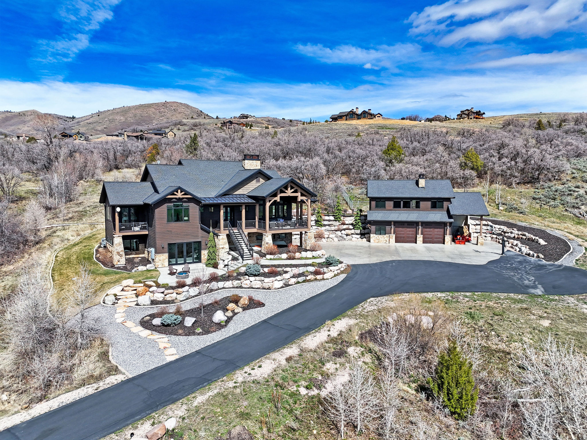 Beautiful Custom Mountain Home on 5.65-acre wooded lot. Property can be extended by acquiring the additional 5.26-acre lot that is also available. Breathtaking panoramic views that you won't find anywhere else. This 5 bedroom 5  bath home includes a separate garage with a 1-bedroom apartment up above. The main house has a wraparound deck and private deck off the Master bedroom so you can enjoy the peaceful setting. The home includes an amazing office with built in desks and cabinetry. The kitchen is equipped with a gas stovetop, double ovens and large pantry. The great room has a beautiful rock fireplace and Hardwood flooring. This home has 4 fireplaces in total. There is so much custom cabinetry and natural stone throughout the entire home. Outside you have a professionally landscaped yard with a large wood fire pit. There is also a gas fire pit on the front patio. You have 3 world-class ski resorts within 5-22 miles of the home. Miles and miles of mountain bike and hiking trails right from the house. This is such a unique property you need to come see it in person! (The ADU / mother-in-law apartment over the detached garage has a full kitchen, family room, bedroom, and full bathroom.  That sq footage is listed in the "3rd floor" section).