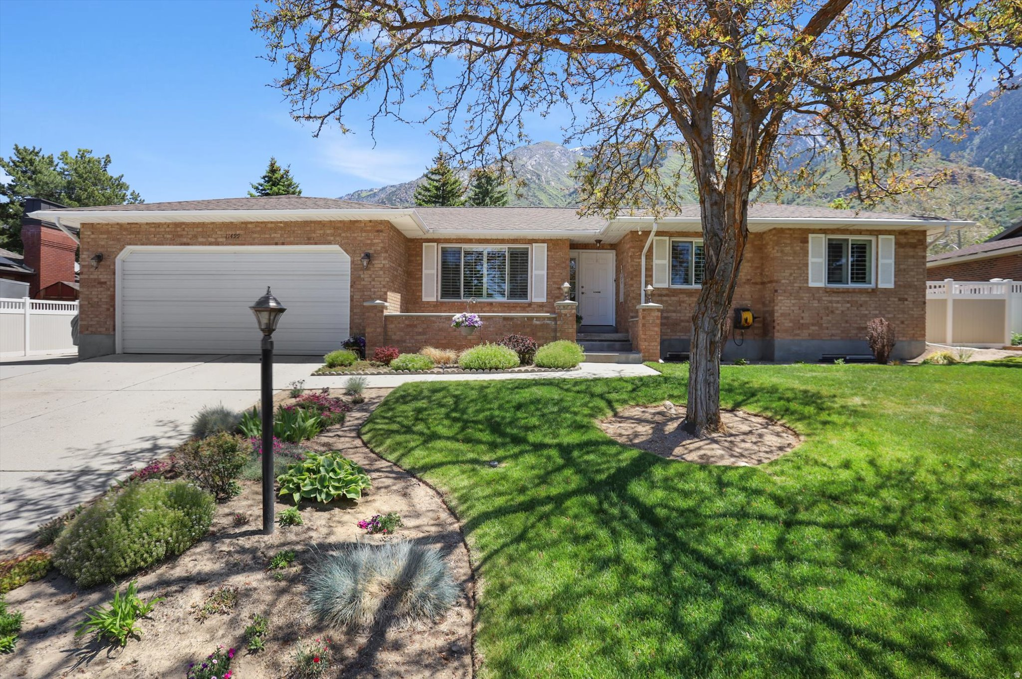 Boasting spectacular mountain views, this rambler is situated in a highly desirable Sandy location and offers an exceptional blend of durability, efficiency, and modern convenience. This home sits on a generously sized 0.25 acre private yard secured by vinyl fencing installed in 2011, featuring a large garden area, a patio perfect for outdoor entertaining, and motion sensor lights added in 2025 for enhanced security. The exterior is built with sturdy 2" x 6" wall construction and includes stainless steel rain gutter guards, a locking brick pillar mailbox, and metal window well covers, while the oversized garage features an 8' door opening, an insulated door, and a dedicated workshop/storage area alongside convenient RV parking. Inside, you'll find 3,000 square feet of living space meticulously maintained with a 2010 roof, 2008 Champion windows, R-49 attic insulation, and a smart sprinkler controller with a phone app. The interior features six bedrooms and 3  bathrooms-upgraded in 2012 with granite countertops and new cabinets-along with a main floor laundry and elegant plantation shutters installed in 2015. Comfort is guaranteed year-round by a radiant hot water floor heat boiler system and central A.C. added in 2014, while safety is prioritized through a comprehensive security system, hard-wired smoke alarms, a radon mitigation system, and a unique emergency freshwater storage and distribution system. Complete with a fresh water filter, a water softener, and a cozy gas fireplace on the lower level,as well as storage room, this home in a quiet soughtafter neighborhood near premier shopping and dining is a true must-see.