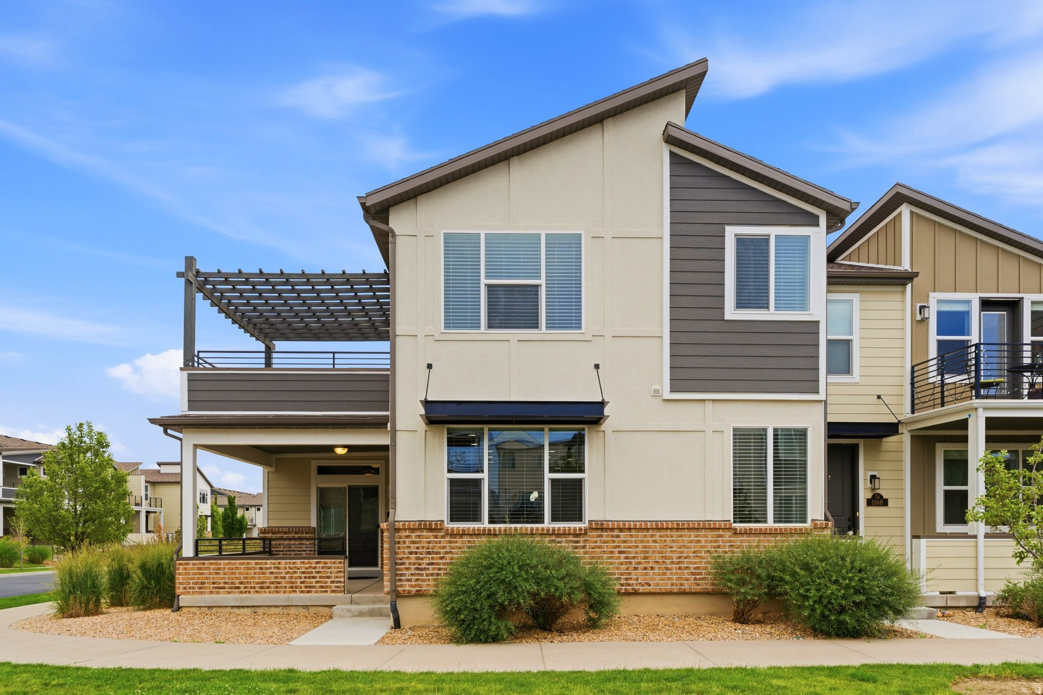 Enjoy easy, low-maintenance living in this desirable end-unit townhome in The Avenues at the Station! Thoughtfully designed for flexibility and convenience, this unique floor plan offers a main-level Primary Suite, spacious living area, kitchen, and half bath. Upstairs, you'll find an expansive great room with a second kitchen, two additional bedrooms, a full bath with a deep soaking tub, laundry area, and a large 13' x 12' deck showcasing stunning mountain views. This versatile layout is ideal for multi-generational living, guests, entertaining, or creating separate living spaces. Quality upgrades throughout include laminate plank flooring, 9-foot ceilings, granite countertops, and decorative tile backsplashes in both kitchens. The spacious Primary Suite features double sinks, a large walk-in shower, walk-in closet, and direct access to the inviting front porch complete with a built-in gas line for grilling. The oversized 2-car garage offers an insulated garage door and additional storage space. Situated in one of the community's premier locations, this end-unit provides added privacy, convenient guest parking, and close proximity to the community pool. Enjoy easy access to walking and biking trails, Station Park's shopping and dining, FrontRunner commuter rail, University of Utah Health facilities, and Western Sports Park.  Square footage figures are provided as a courtesy estimate from county records. Buyer is advised to obtain an independent measurement.