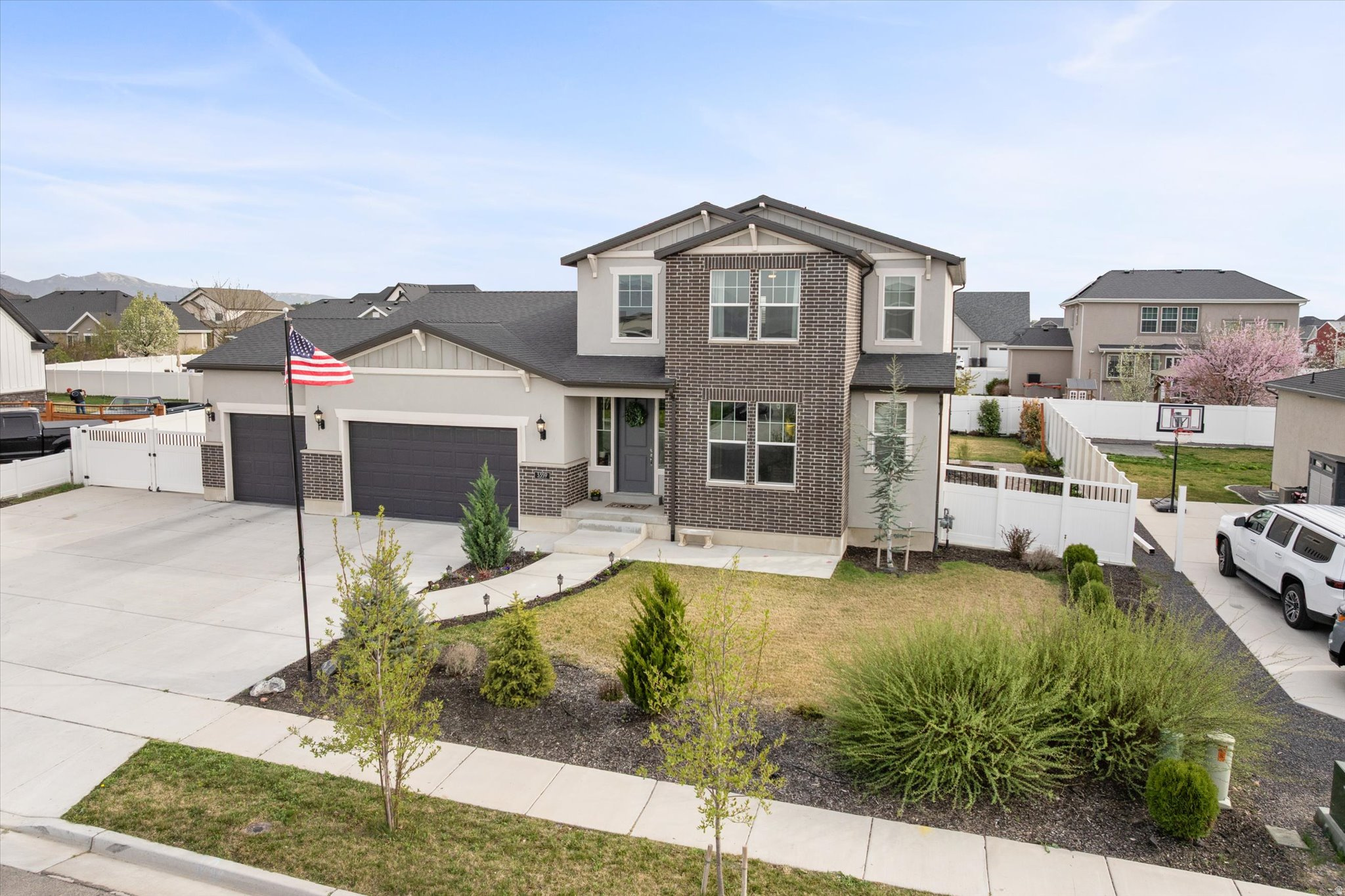 Come see this stunning two-story farmhouse-style home located in a highly sought-after master-planned community. Thoughtfully designed with both luxury and functionality in mind, this home offers a seamless blend of modern technology and warm, inviting living spaces. The heart of the home is the beautifully appointed kitchen, featuring a premium Wolf Pro Range gas convection oven and a state-of-the-art GE Stainless Steel Kitchen Hub with built-in cameras, guided cooking, Google Assistant integration, and entertainment features. A spacious pantry and tile flooring throughout all wet areas add both convenience and durability. The home is fully equipped with GE Cync smart home technology, providing effortless control of lighting and systems. A discreet wall safe in the primary closet adds an extra layer of security. The fully finished basement is designed for entertaining, complete with a custom theater featuring Dolby Atmos surround sound, a 4K projector, and in-wall speakers. A stylish wet bar with a 150-can beverage fridge makes hosting easy. A charming custom playroom tucked beneath the stairs offers a fun and imaginative space, while one of the basement bedrooms features a vault door and concealed Murphy door for added security and versatility. The downstairs bathroom includes a Moen Smart Shower with digital temperature control, rain shower, and handheld wand for a spa-like experience. Step outside to a beautifully finished backyard designed for both relaxation and entertaining. Extensive masonry creates a large patio with a built-in fire pit-perfect for gatherings and quiet evenings. The yard is fully fenced with a large vehicle gate and extended driveway for additional parking. Illuminated walkways and low-voltage landscape lighting enhance both ambiance and security, while the WiFi-enabled multi-zone irrigation system keeps the yard looking its best. Additional features include multimedia wiring in every bedroom, custom window well covers, a water softener, and abundant storage throughout the garage, attic, and mechanical areas. Enjoy beautiful views and unforgettable sunsets from both the front and backyard in a home that perfectly combines comfort, security, and modern farmhouse charm.