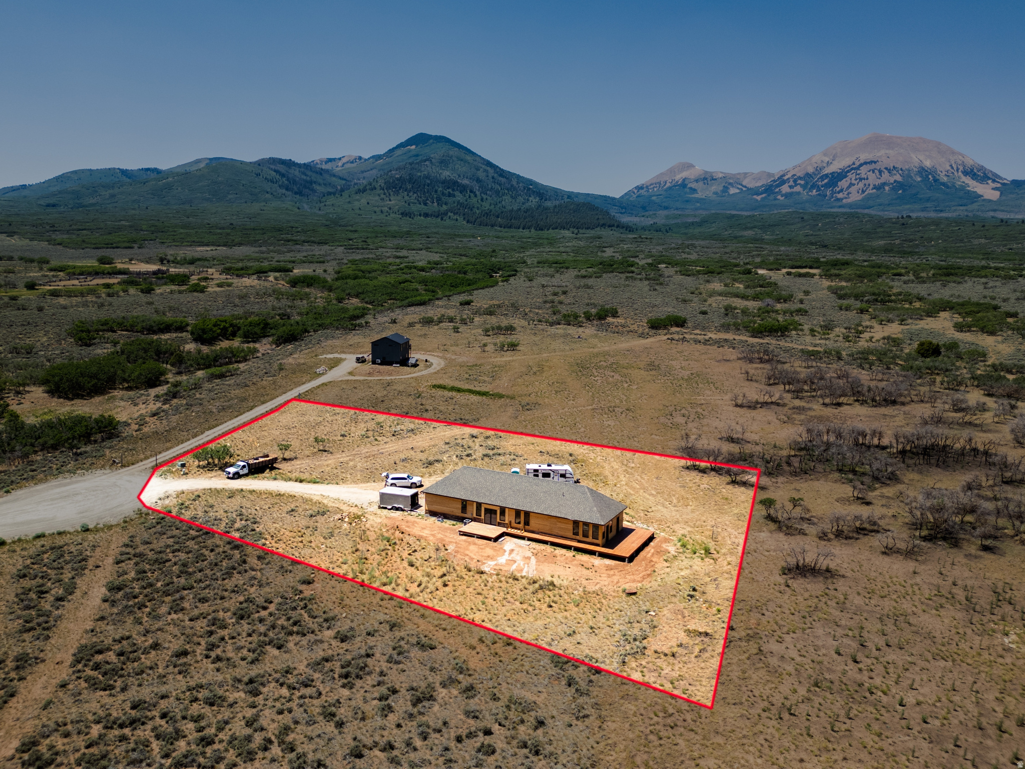 Front Row La Sal Mountain Views define this exceptional new construction home on 10 private acres in Old La Sal, scheduled for completion by August 1. Perfectly positioned at the end of quiet and peaceful Porcupine Lane, this property offers unobstructed, protected views of the La Sal and San Juan Mountains, creating an extraordinary mountain setting that is increasingly difficult to find.  Designed to embrace the surrounding landscape, the home features an open, light-filled floor plan with expansive picture windows, handcrafted wood baseboards and custom door casings, quality finishes, and stainless steel kitchen appliances. More than 1,200 square feet of wraparound decking provides exceptional outdoor living space, including a private deck off the bedrooms that is already wired and ready for a hot tub, making it the perfect place to relax while enjoying panoramic mountain views by day and spectacular dark skies at night.  The attached extra-height two-car garage is ready for a bathroom or wash station, and offers plenty of room for vehicles and mountain gear, while the 10-acre homesite provides exceptional flexibility for future expansion. The property allows for two additional buildings, offering the opportunity to construct a barn, workshop, detached garage, guest casita, or studio to fit your lifestyle.  Located in the peaceful Deer Haven community, this home offers the ideal balance of privacy, year-round access, fiber internet availability, and cool mountain summers, all within an easy drive of Moab's world-class recreation. Whether you're seeking a full-time residence, mountain getaway, or recreational retreat, this is a rare opportunity to own a brand-new custom home with some of the finest protected mountain views in southeastern Utah.