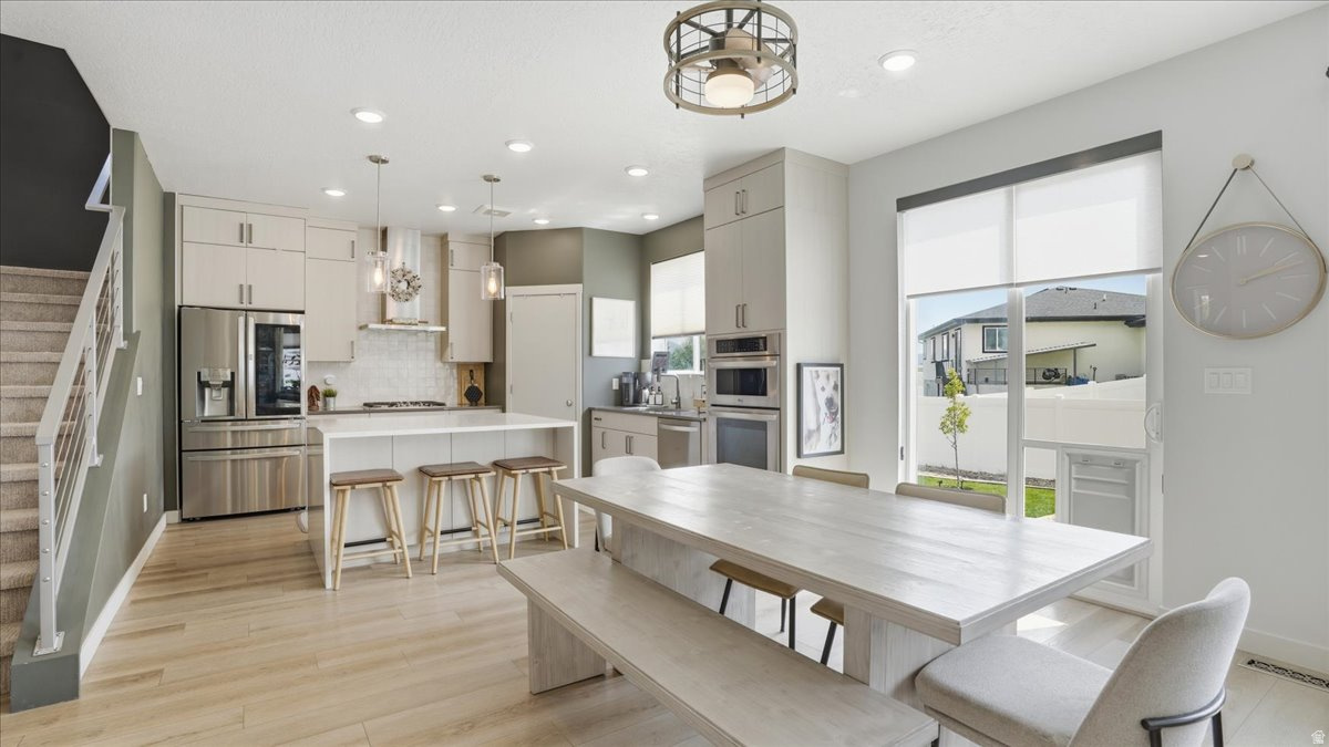 **Multi Generational Living Options** Conveniently located minutes from Bangerter Highway and 20 minutes to Salt Lake international Airport.  This stunning home combines thoughtful design and functionality throughout. The custom kitchen showcases premium full length cabinets, pantry, gas range, wall oven and microwave. The main level offers a versatile bedroom or flex space with a full bath, perfect for guests, office, or multi-generational living. Upstairs you'll find a spacious primary suite with ensuite, two additional bedrooms and a loft area with potential for future bedroom. The finished basement expands your living options with a kitchenette (another great option for multi generational living!) two bedrooms, a full bathroom, and flex space. A large yard designed for enjoyment, featuring multiple patio areas, expansive entertaining space, RV parking, and full-perimeter Govee lighting.  Additional conveniences include a garage utility sink, overhead storage racks, and outdoor shed. Custom top-down/bottom-up window coverings throughout provide both privacy and natural light control, completing this truly move-in-ready home. Square footage figures provided as a courtesy, obtained from county records. Buyer is advised to obtain an independent measurement.